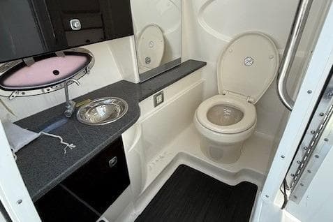 2015 Formula 310 Bowrider bathroom with sink, toilet, and mirror.