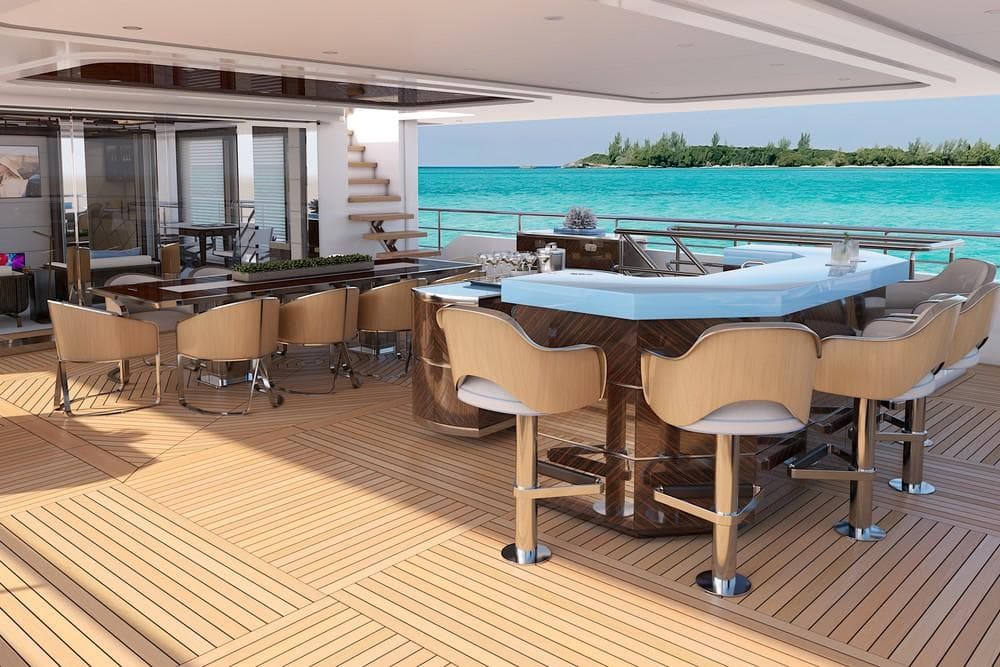 Luxurious yacht deck with bar and seating, overlooking turquoise ocean waters.