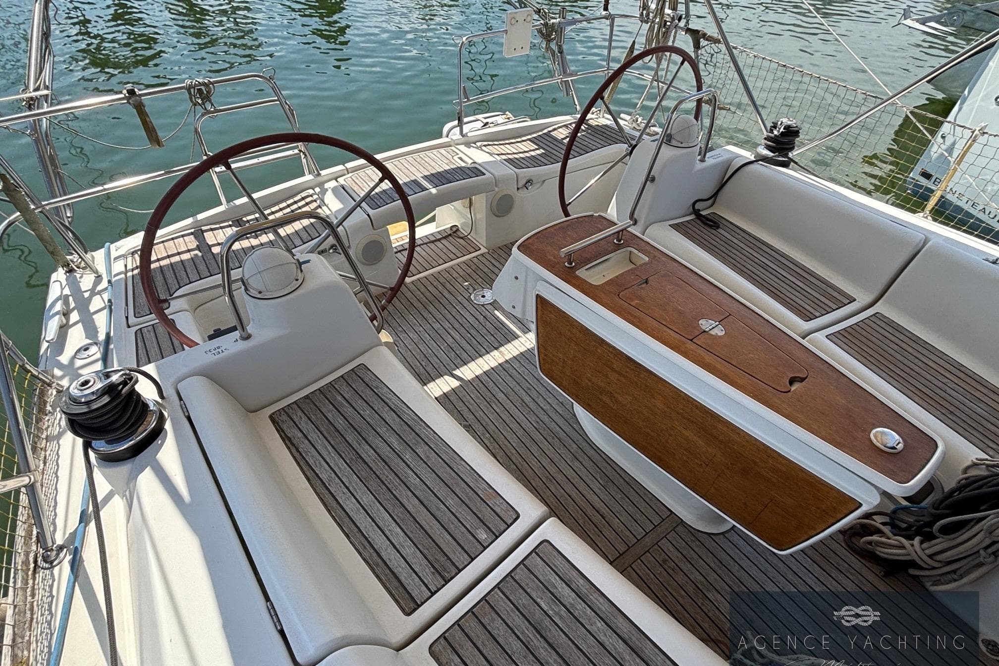 Cockpit of 2008 Beneteau Oceanis 40 sailboat with dual steering wheels and teak flooring.