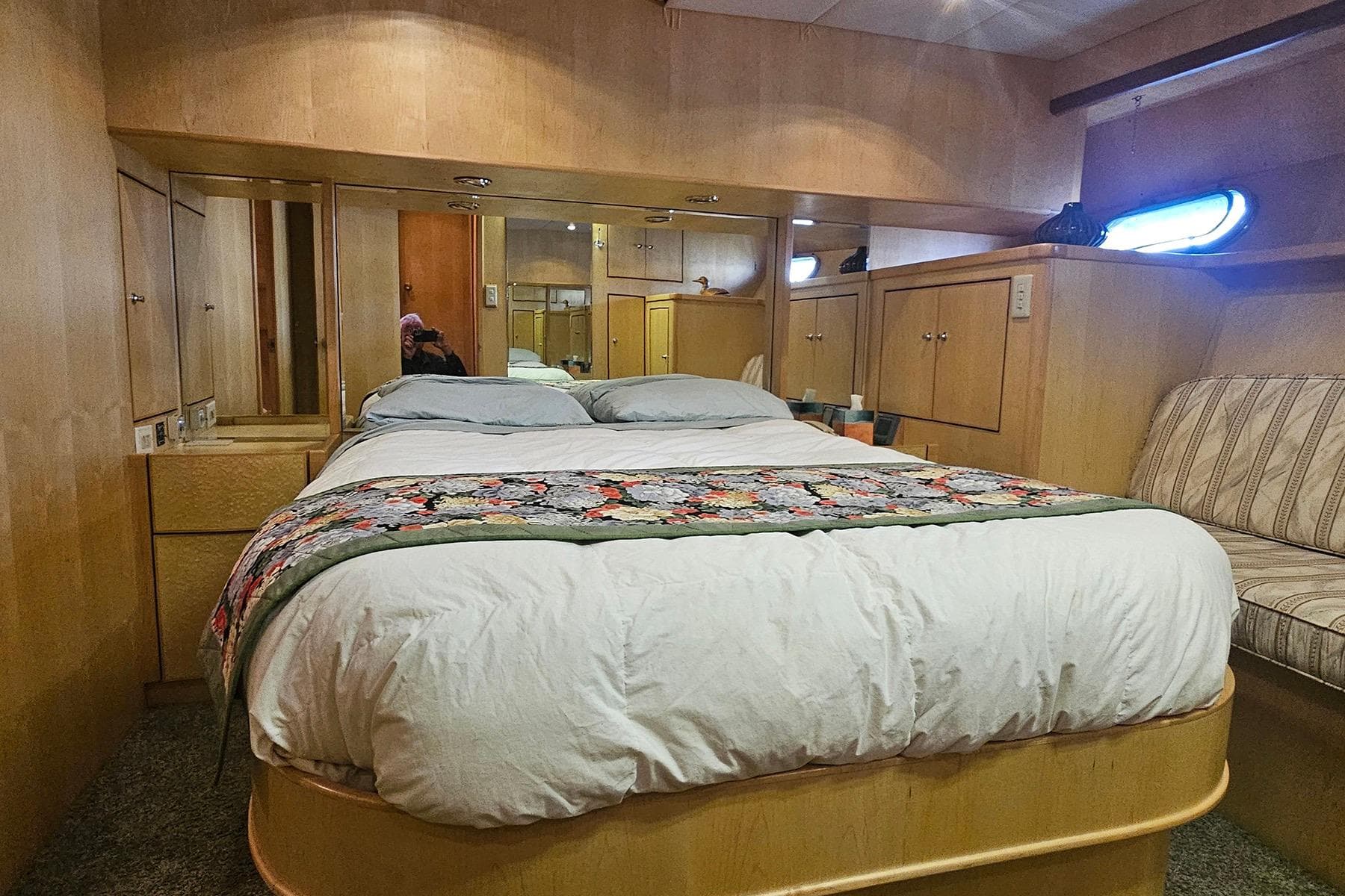 Cozy bedroom interior on a 1995 Symbol 55 yacht, featuring a comfortable bed and wooden cabinetry.