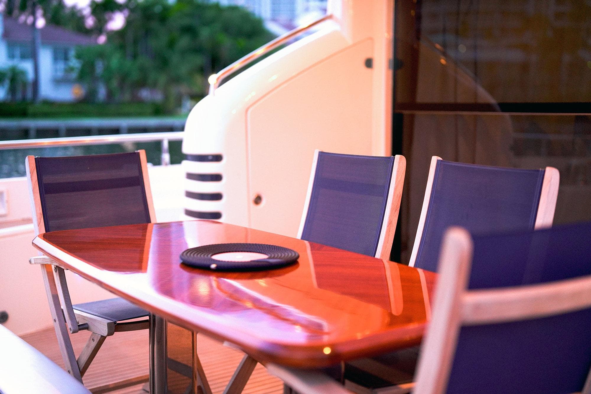Outdoor dining area on a 2007 Princess 23M yacht with elegant wooden table and chairs.