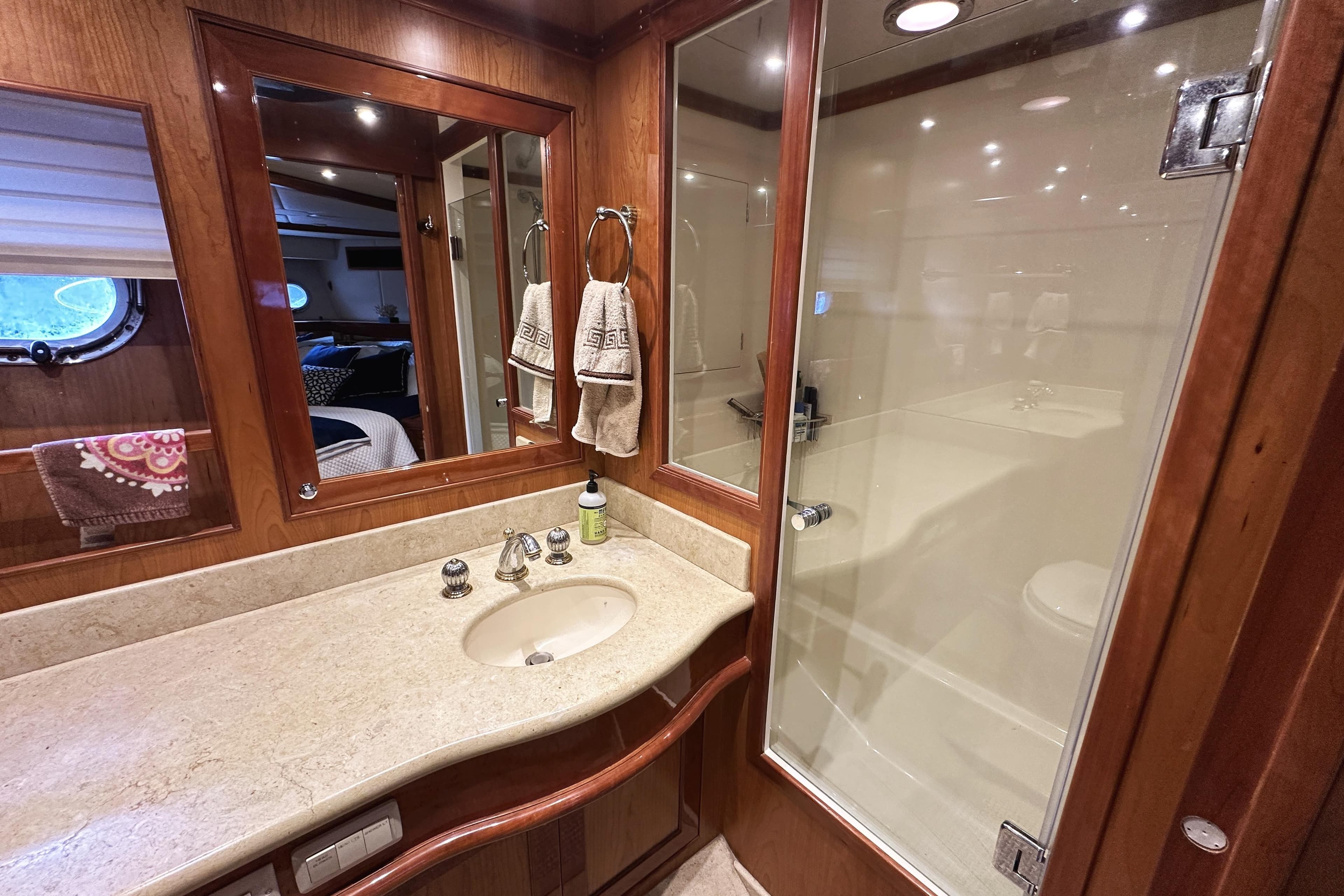 Luxurious bathroom in 2004 McKinna 57 PHMY yacht with wood accents and glass shower.
