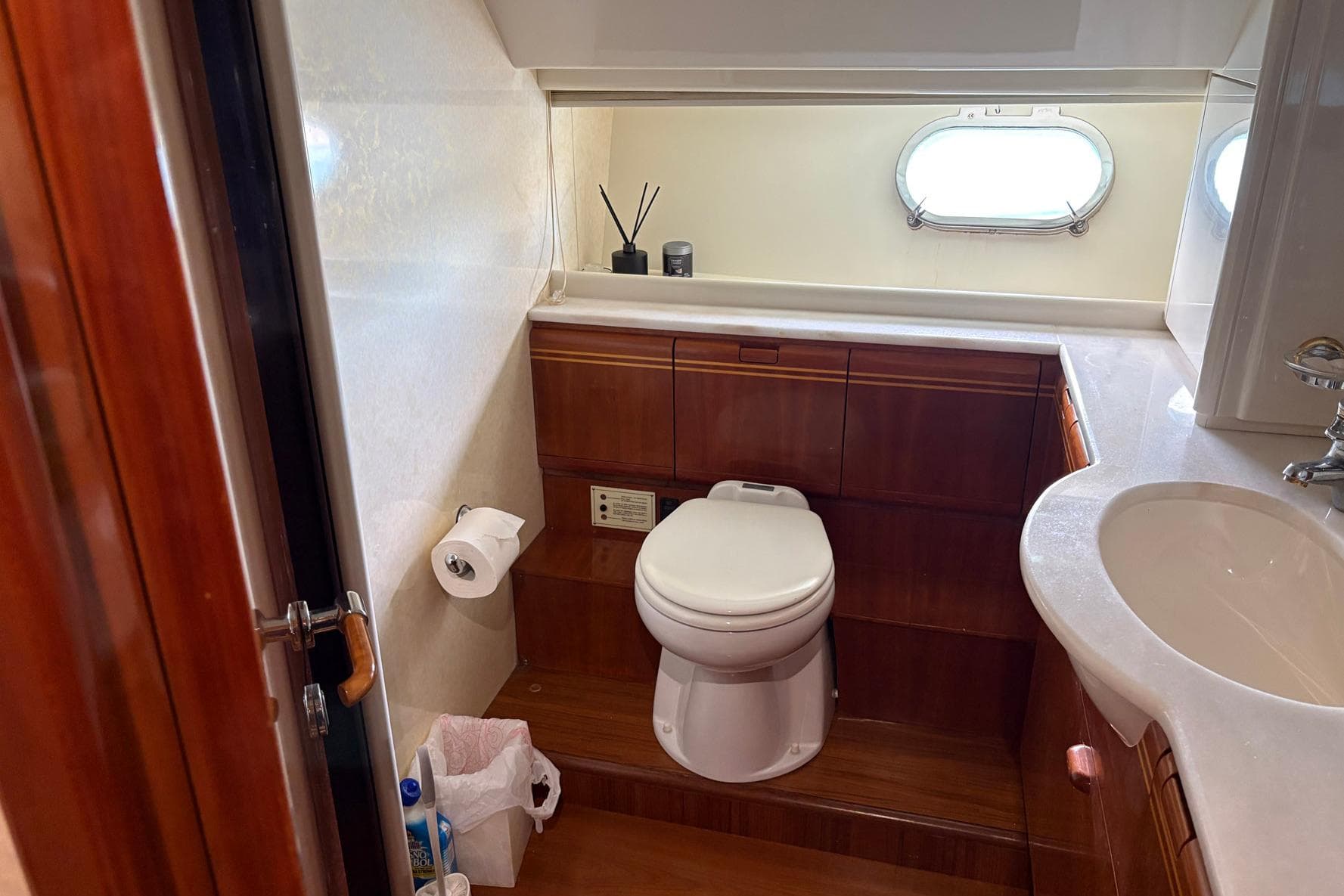 Luxurious bathroom in 1999 Ferretti Yachts 80 RPH with wooden cabinetry and porthole window.