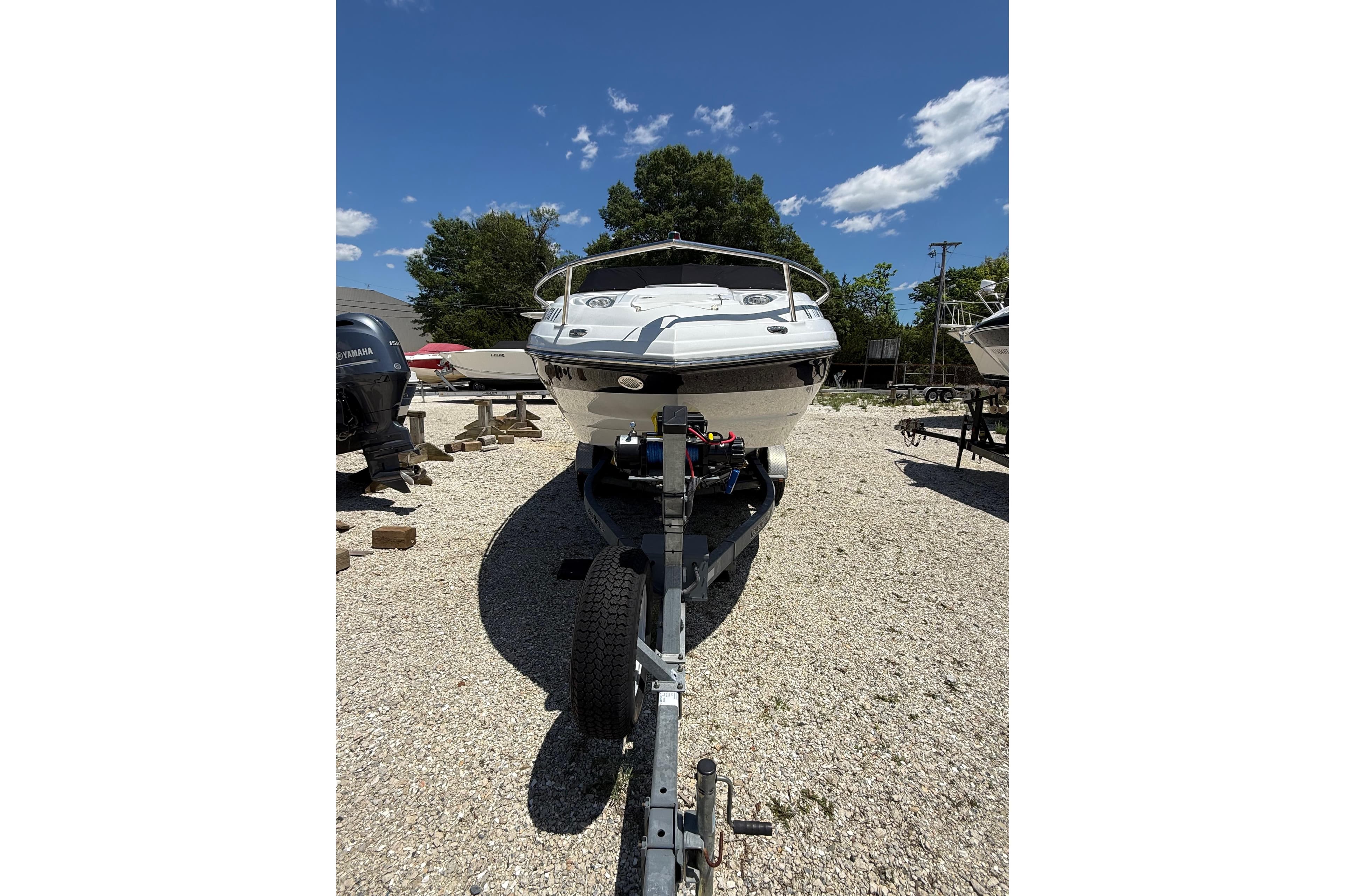 2011 Crownline 236 SC boat on trailer under clear blue sky.