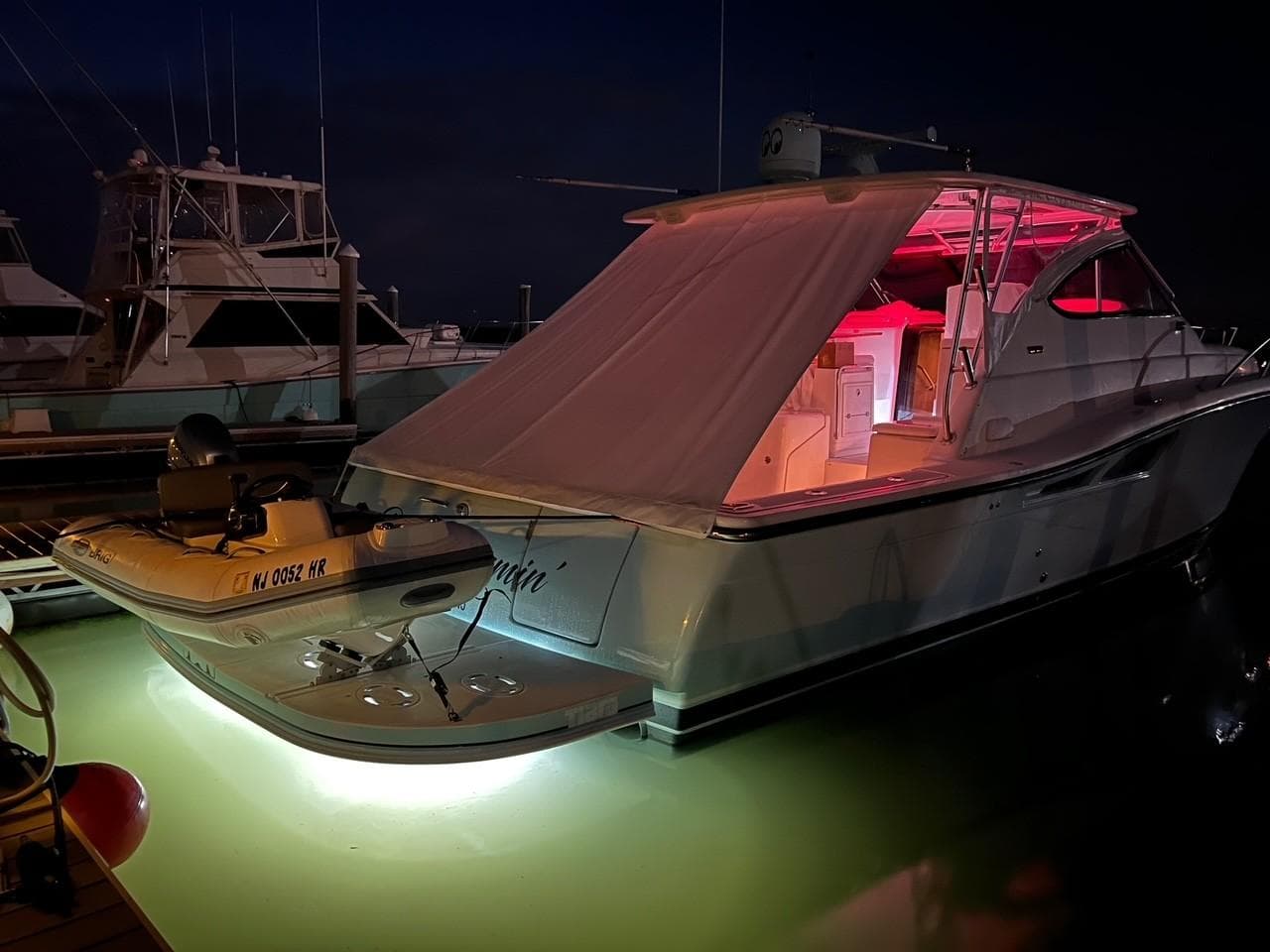 2005 Tiara Yachts 4200 Open with illuminated deck at night, docked in marina.