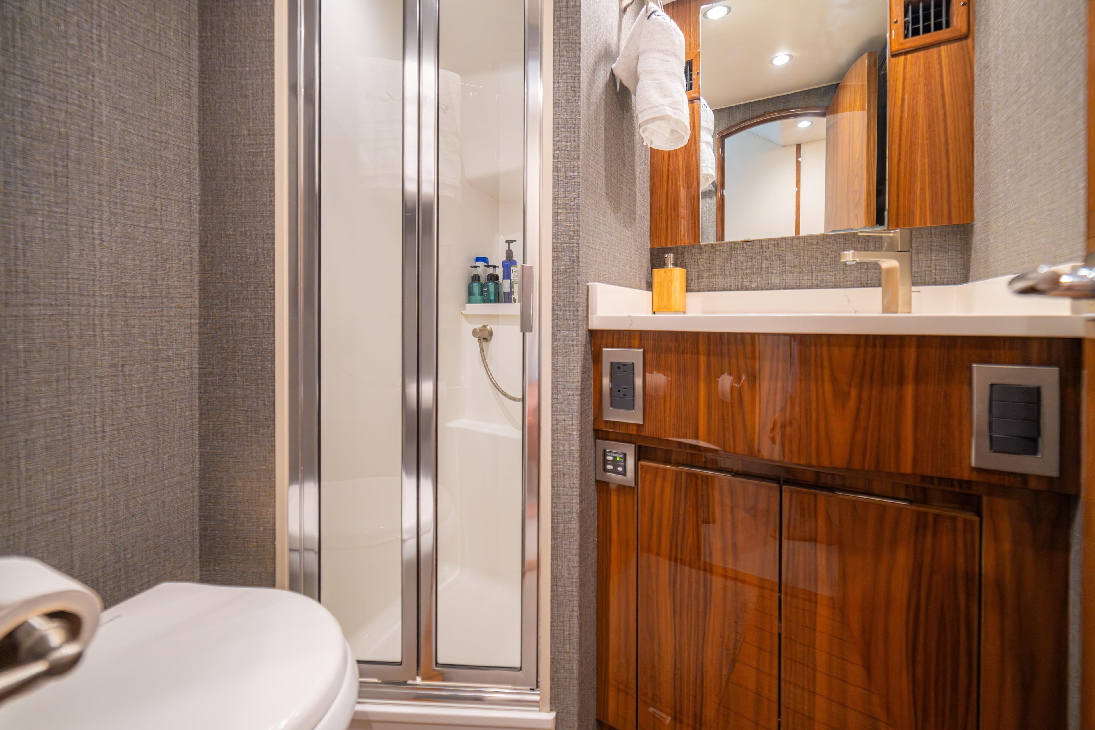 Luxurious bathroom in 2024 Viking 48 Convertible yacht with modern fixtures and wood cabinetry.