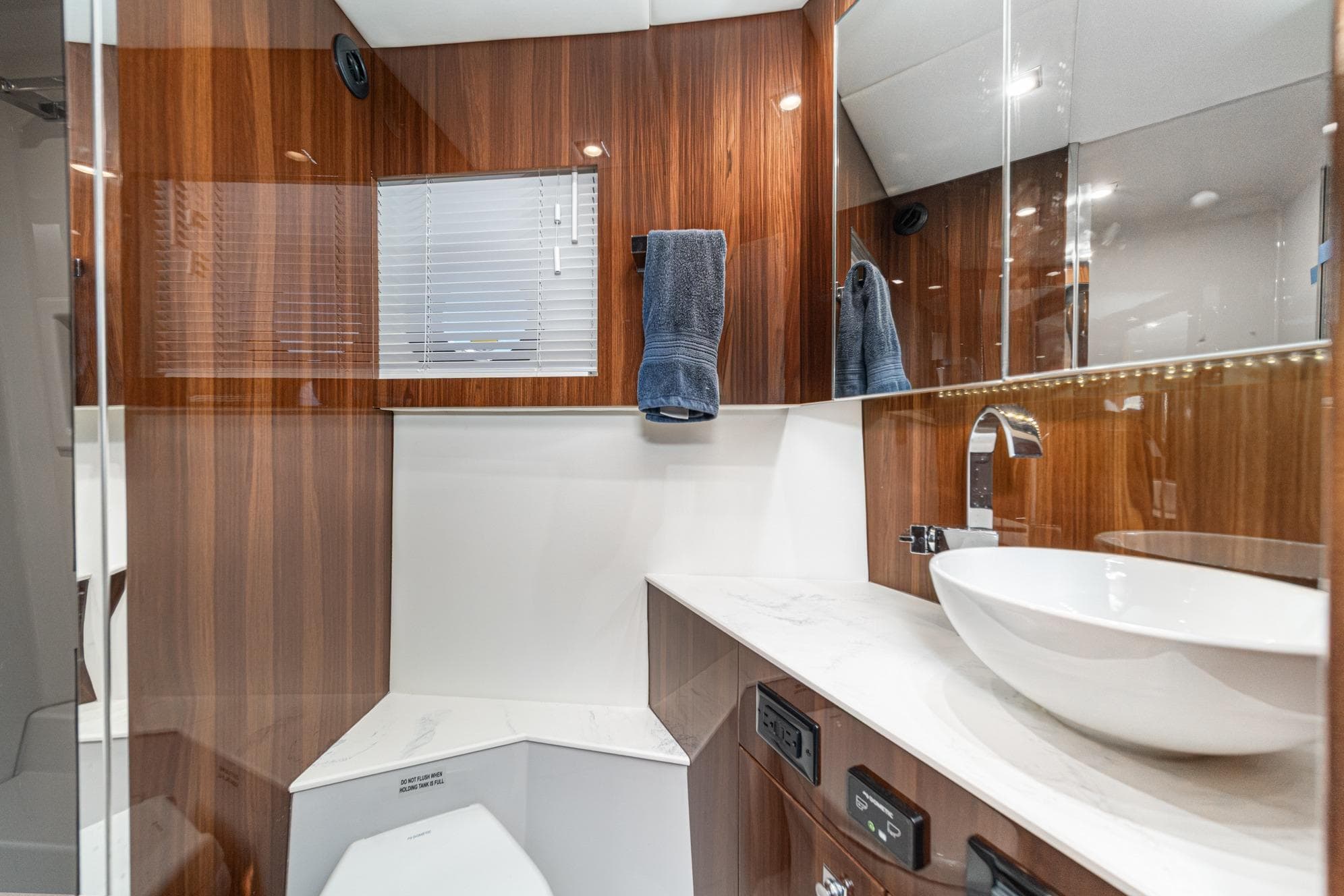 Luxurious bathroom in 2023 Cruisers Yachts 42 Cantius with modern fixtures and wood accents.