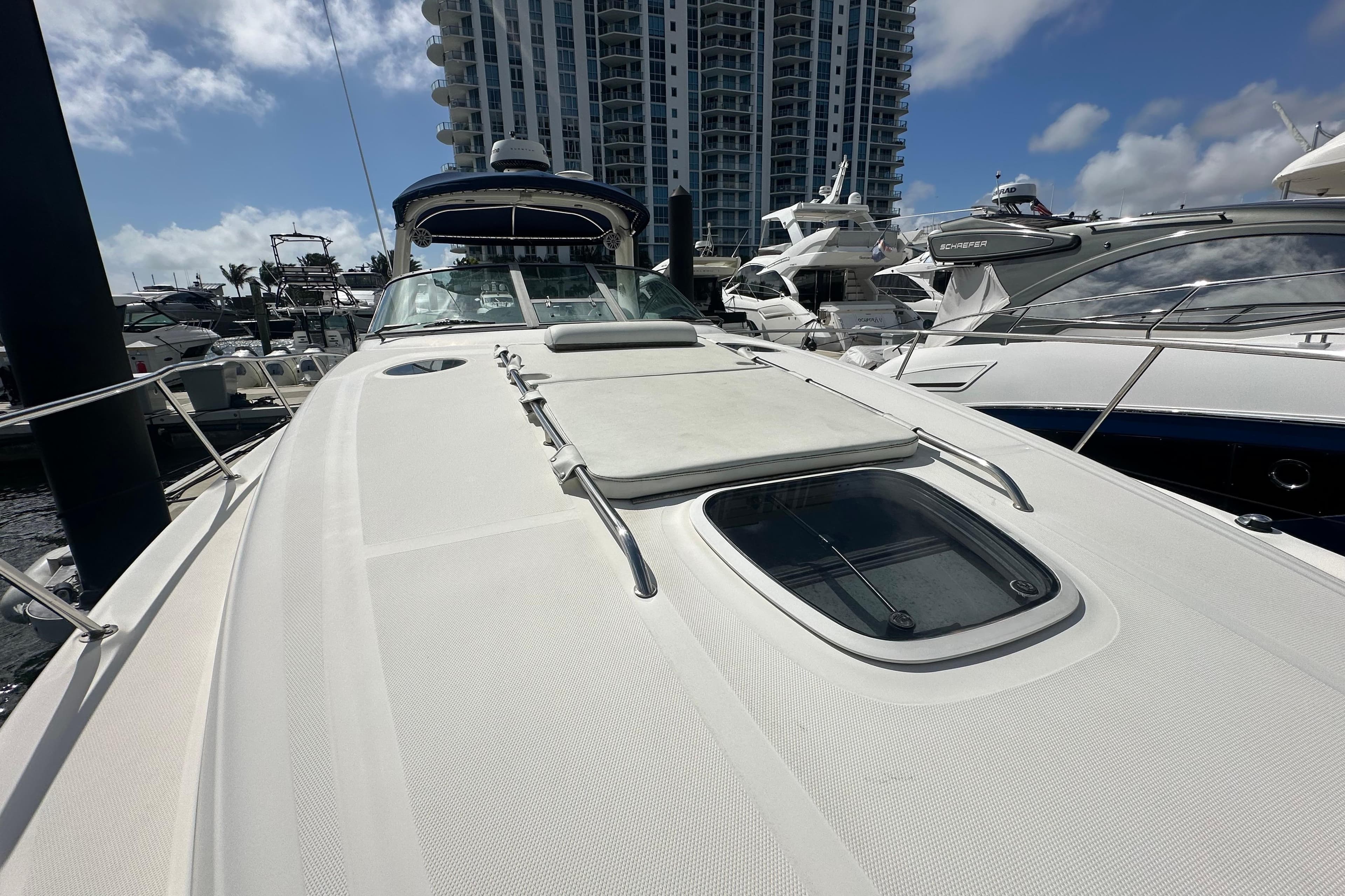 2008 Sea Ray 340 Sundancer yacht docked at marina with modern buildings in background.
