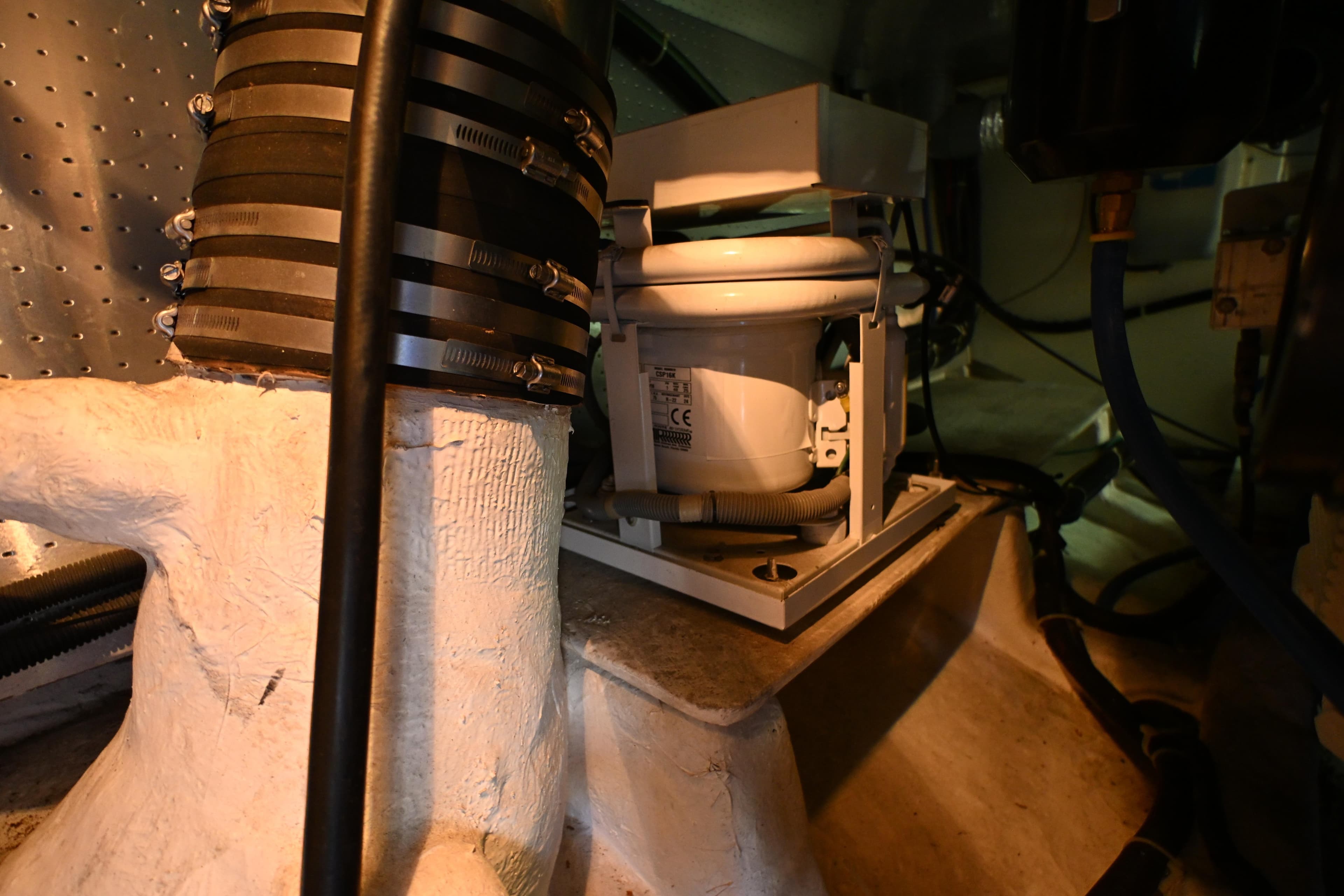 Engine room of a 1999 McKinna 47 Sedan yacht, showcasing mechanical components and piping.