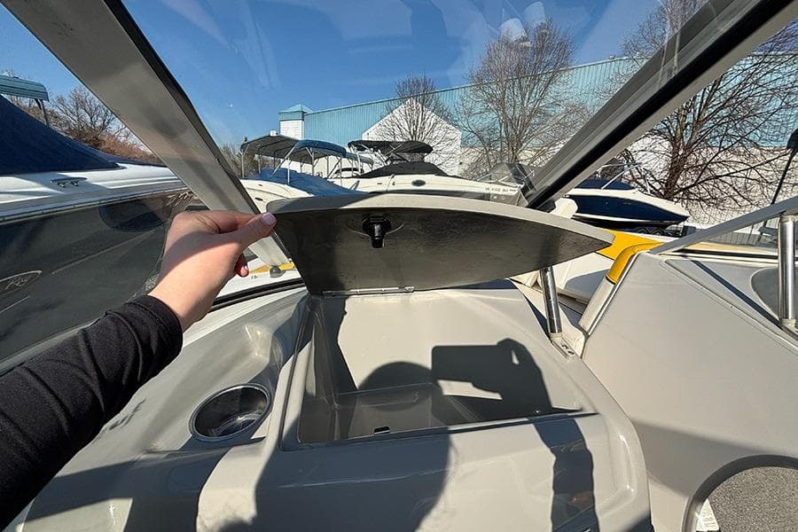 2012 Bayliner 185 Bowrider interior with open storage compartment and cup holder.