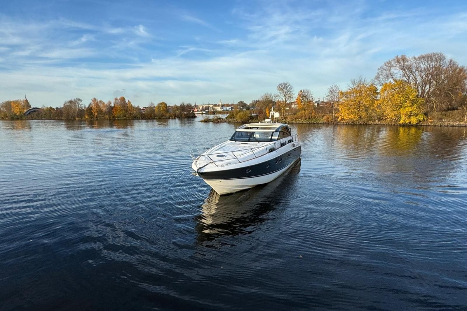 2008 Princess V58 yacht cruising on a calm lake with autumn trees in the background.