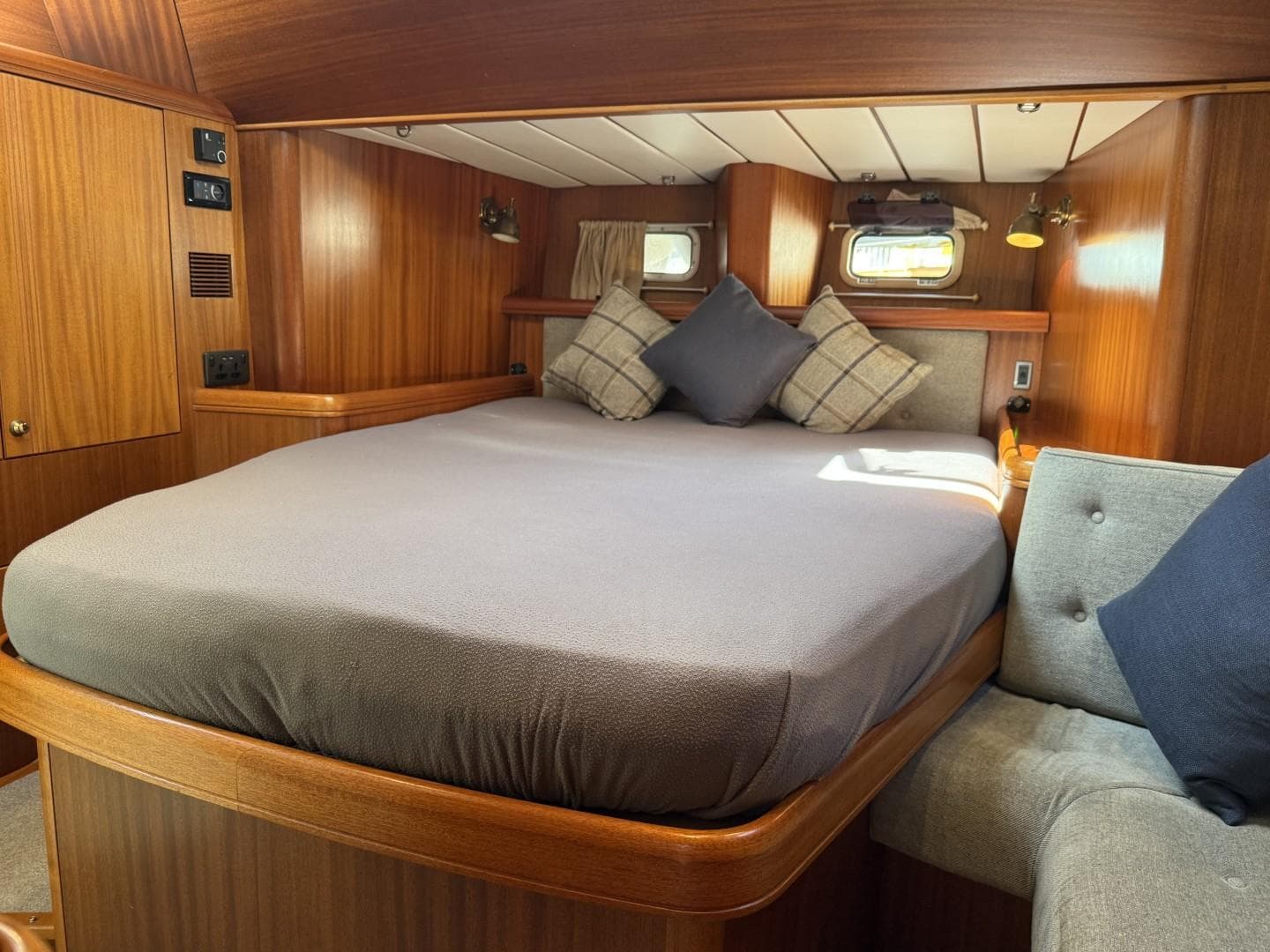 Cozy cabin interior of 2002 Najad 490 yacht with wooden finish and plush bedding.