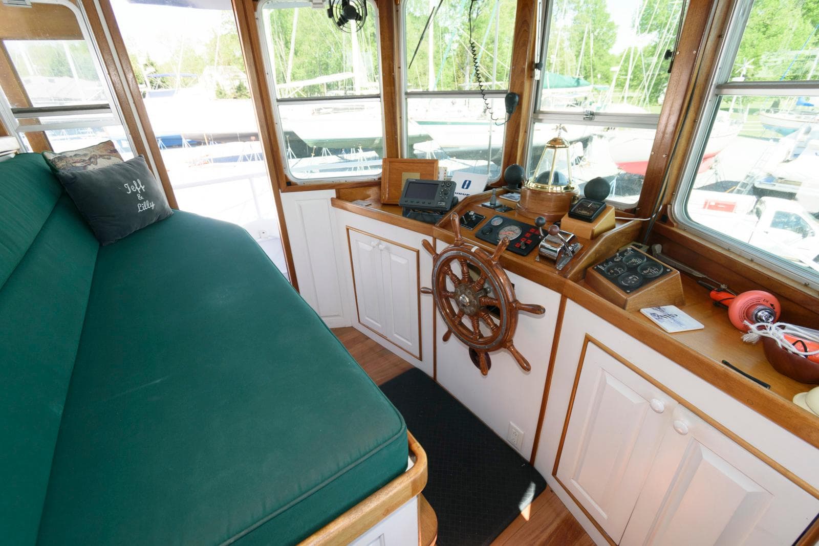 1997 Florida Bay Coasters 35 interior with green seating, wooden helm, and navigation equipment.
