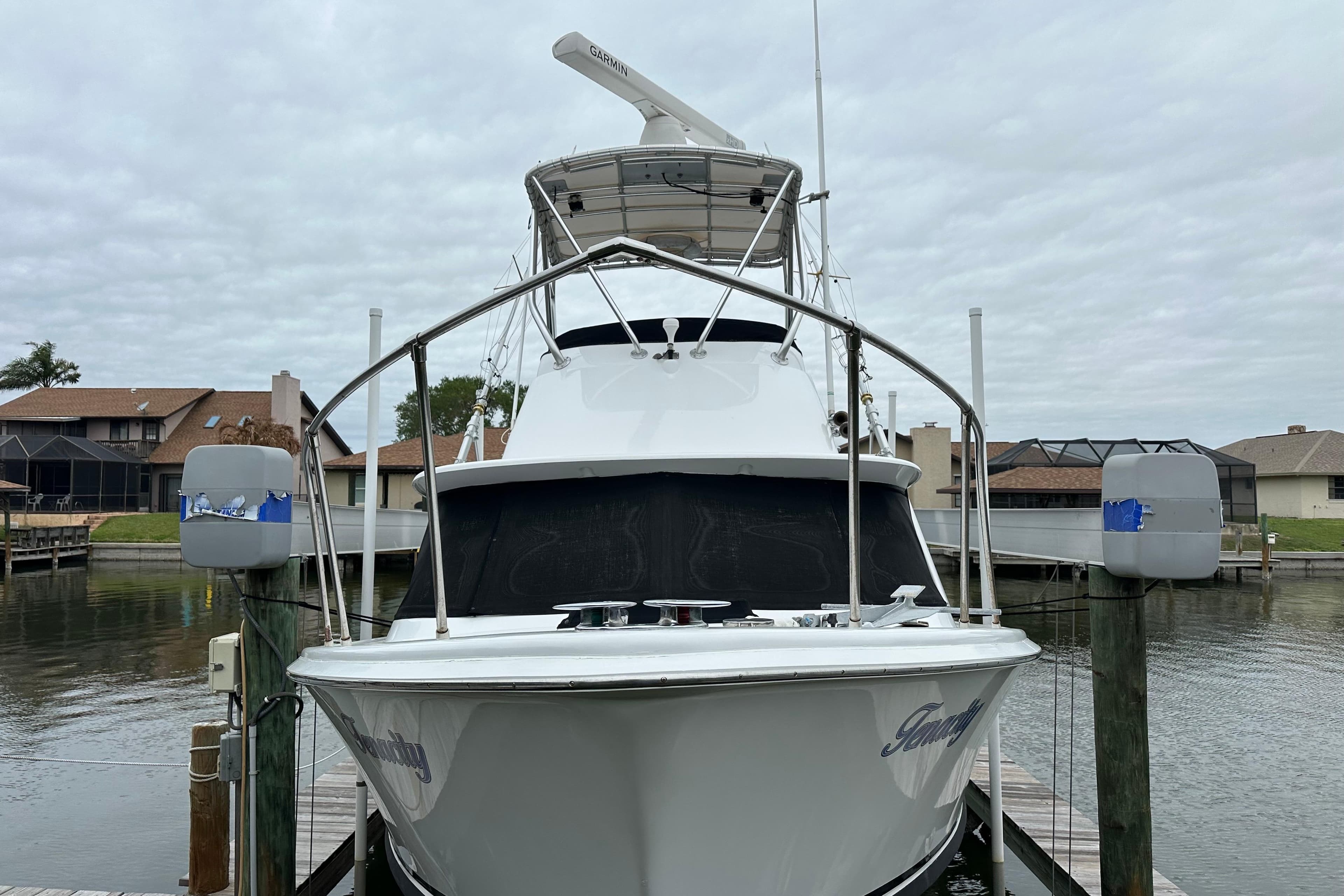 1975 Bertram 31 boat docked at marina, front view with overcast sky.