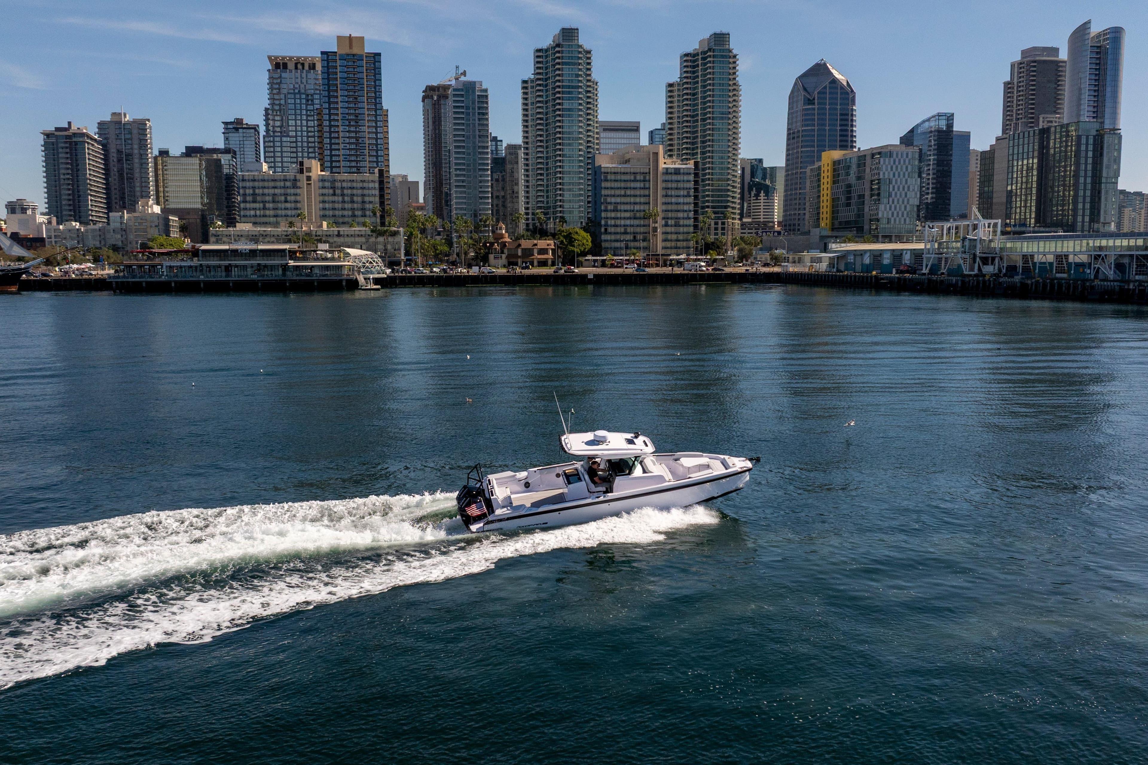 2026 Axopar AX29 CCX cruising near city skyline on a sunny day.