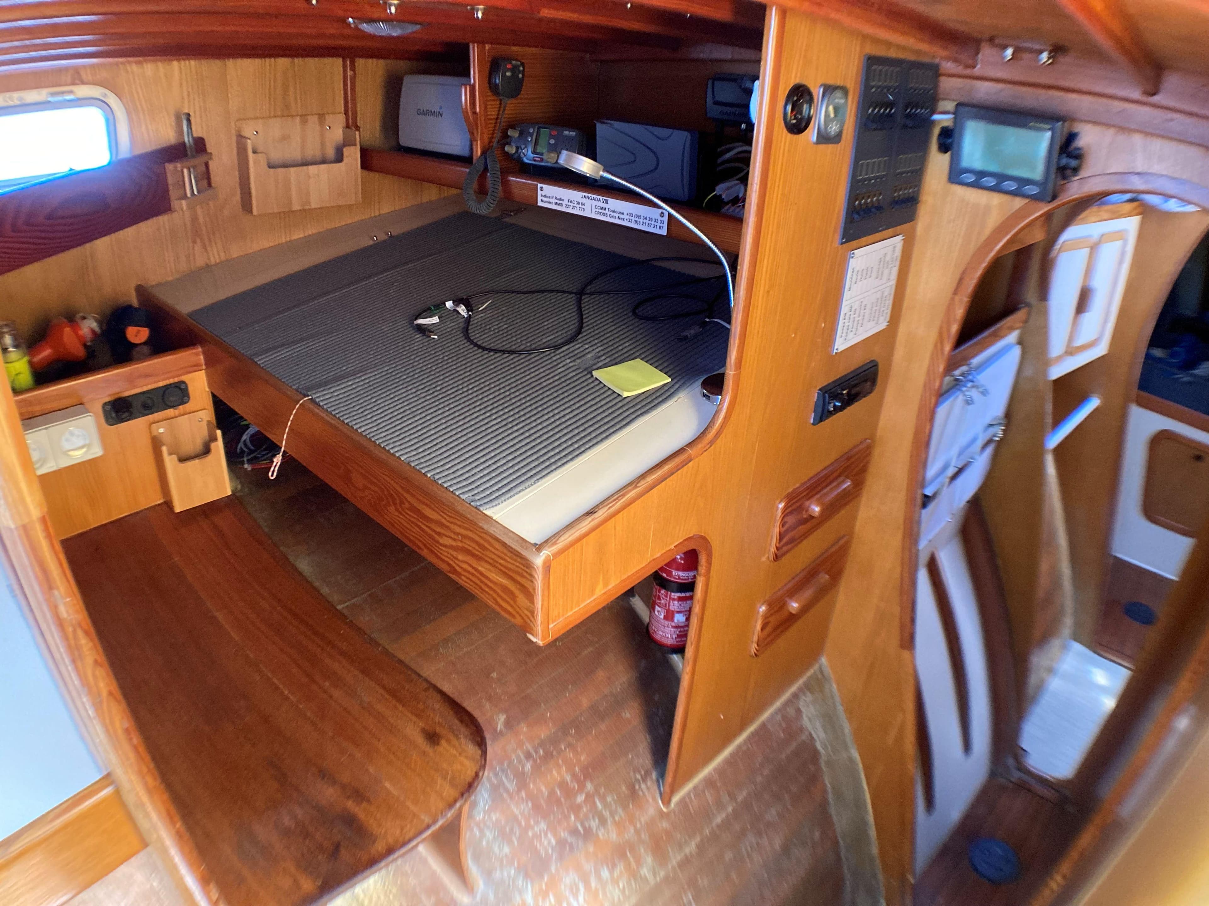 Interior of 2002 Custom TRIMARAN POLYNESIA 45, featuring wooden cabin and navigation equipment.