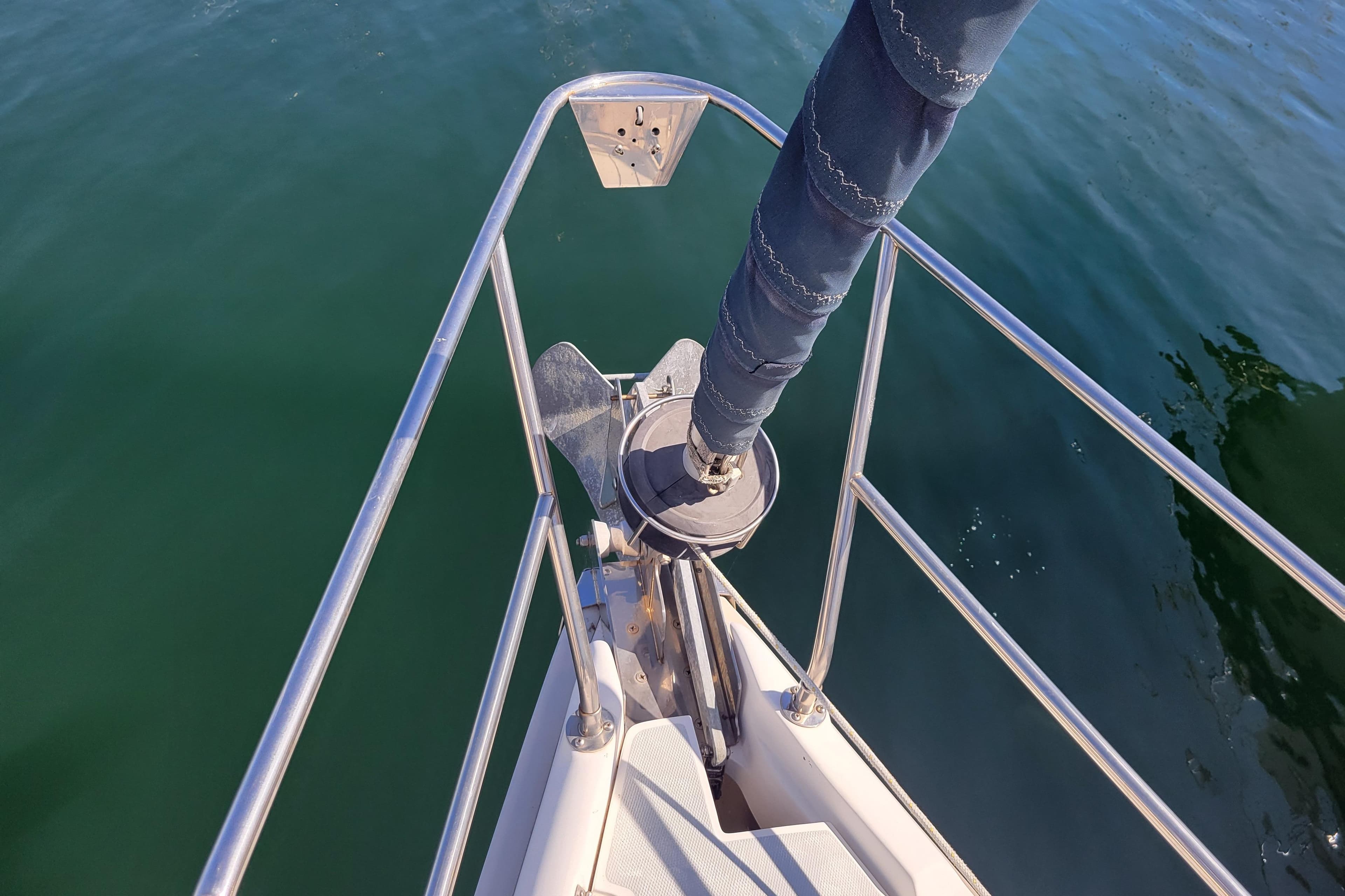 Bow of 2001 Hunter Passage 420 sailboat with anchor and calm water.