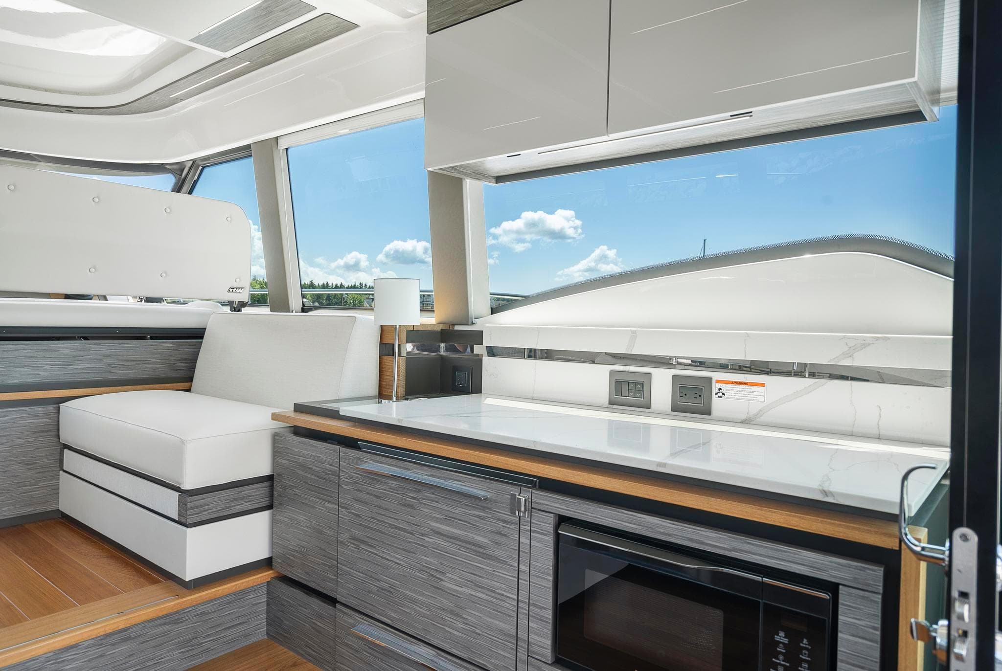 Luxurious interior of 2022 Tiara Yachts C49 Coupe with modern seating and kitchen amenities.