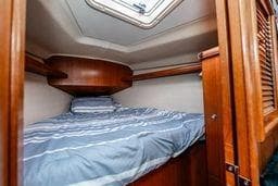 Cozy cabin interior of 2003 Hunter 356 sailboat with wooden finish and skylight.