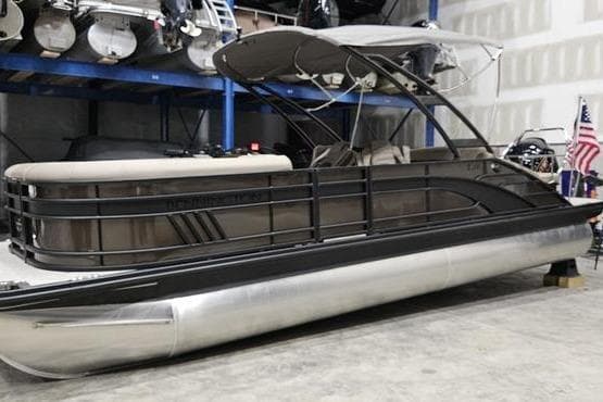 2026 Bennington 24 LSBA pontoon boat in a storage facility, featuring sleek design and canopy.