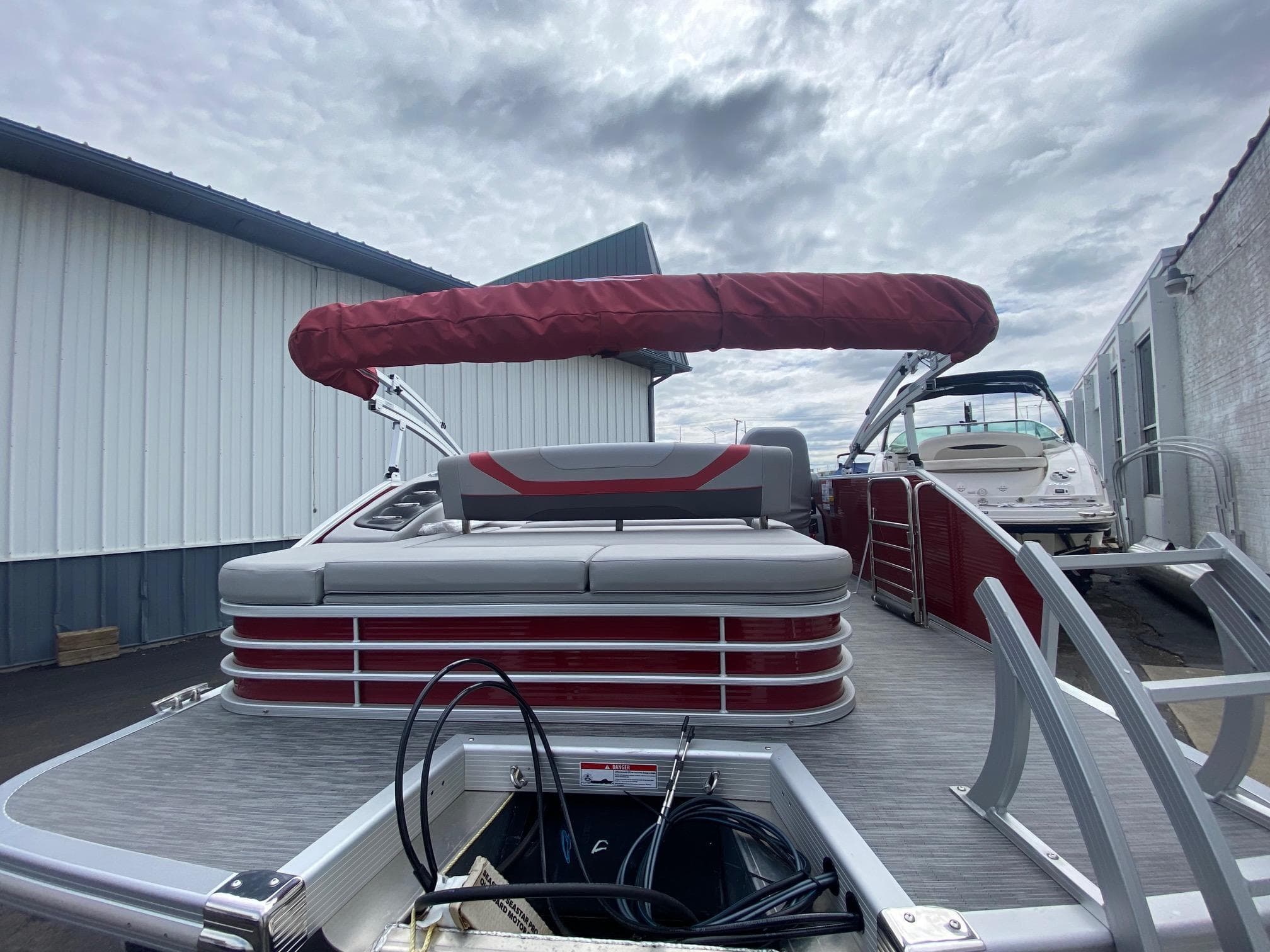 2023 Bennington 21 SXSB pontoon boat with red canopy and gray seating.