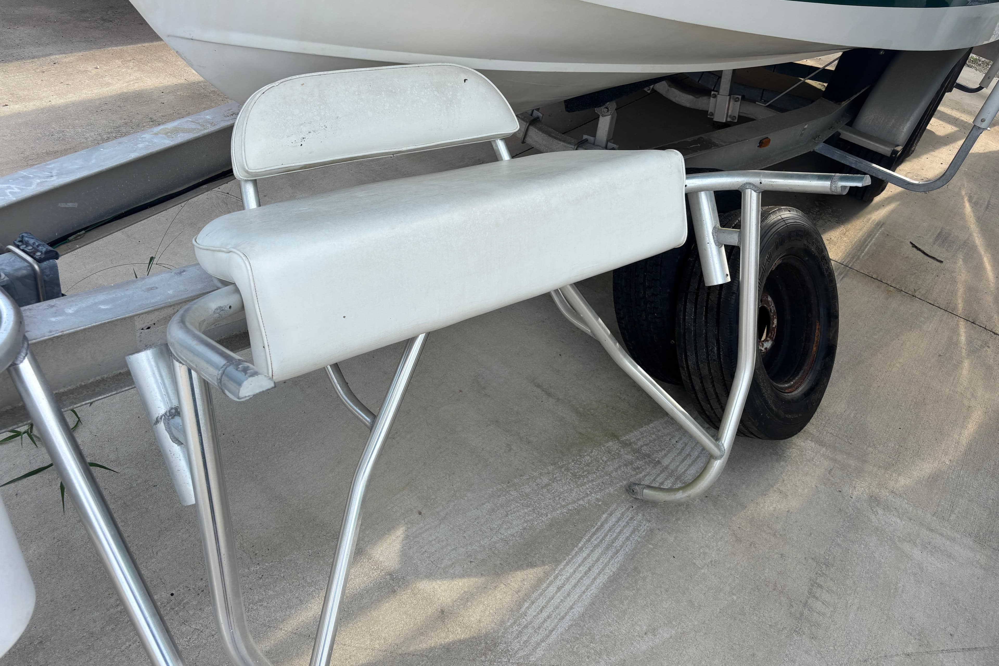 Boat trailer with seating, Shamrock 260 Express, 2000 model, parked on concrete surface.