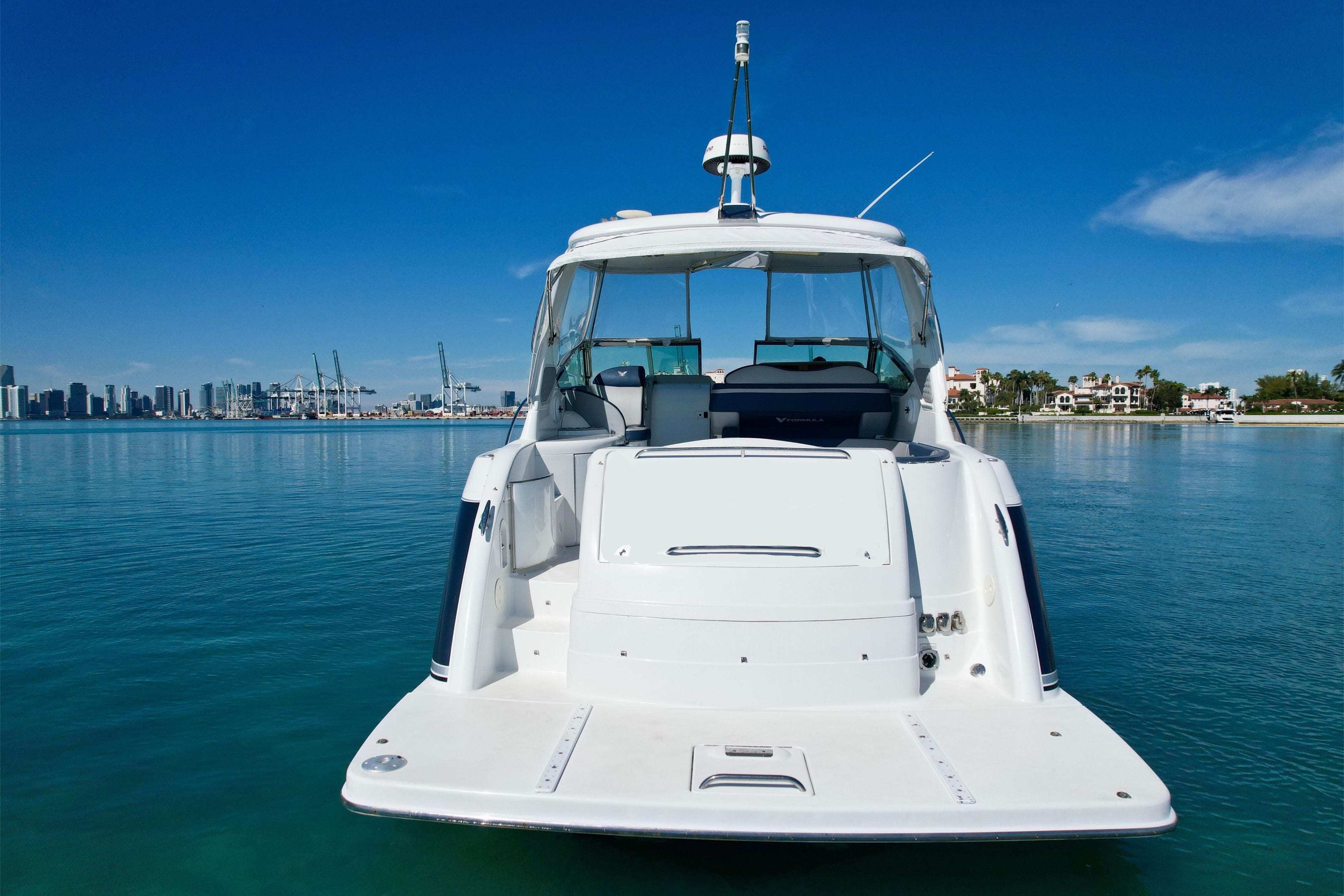 2006 Formula 40 Performance Cruiser on calm water with city skyline in background.