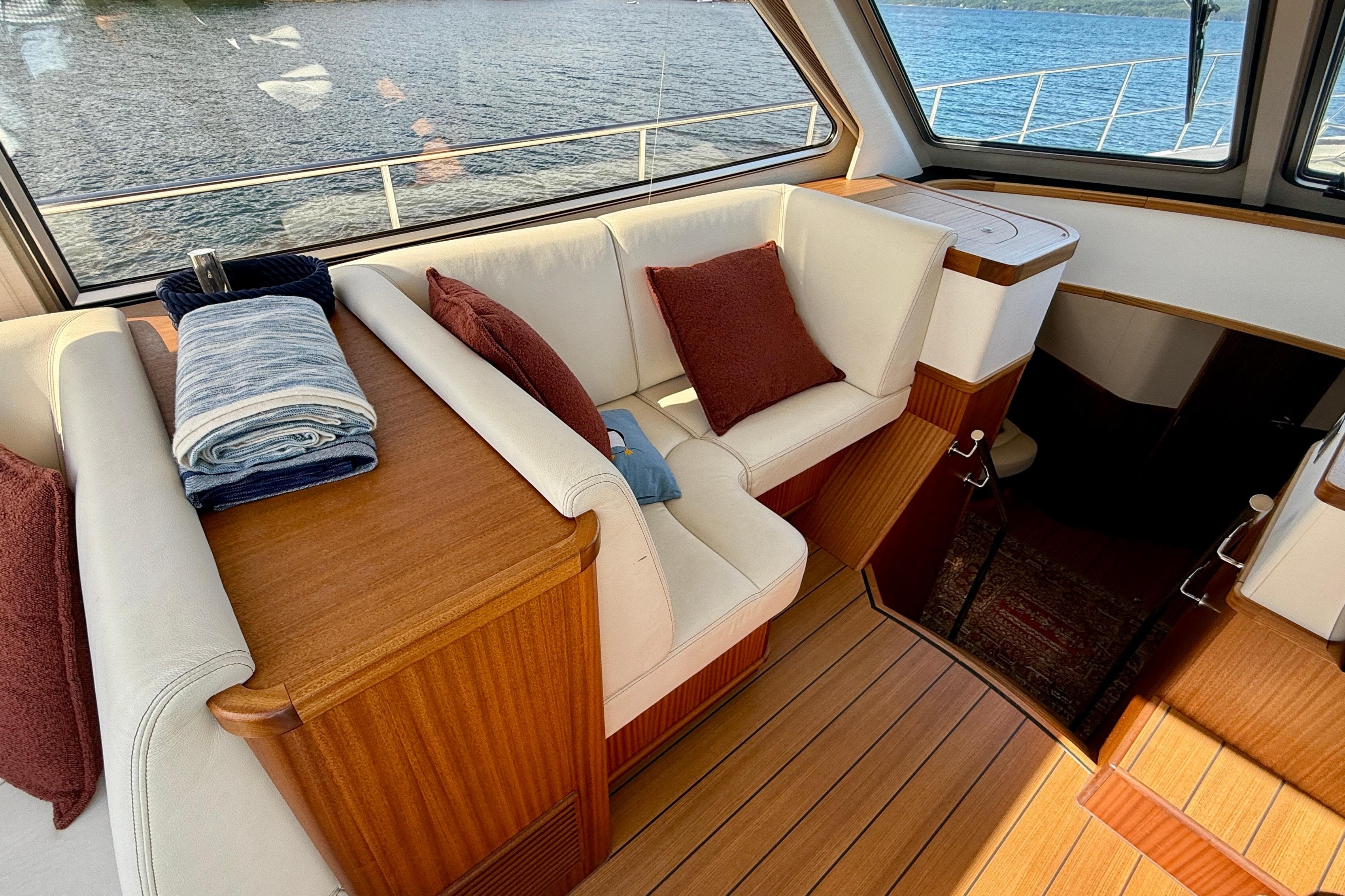 Luxurious interior of 2021 Elling E6 yacht with plush seating and elegant wood finishes.