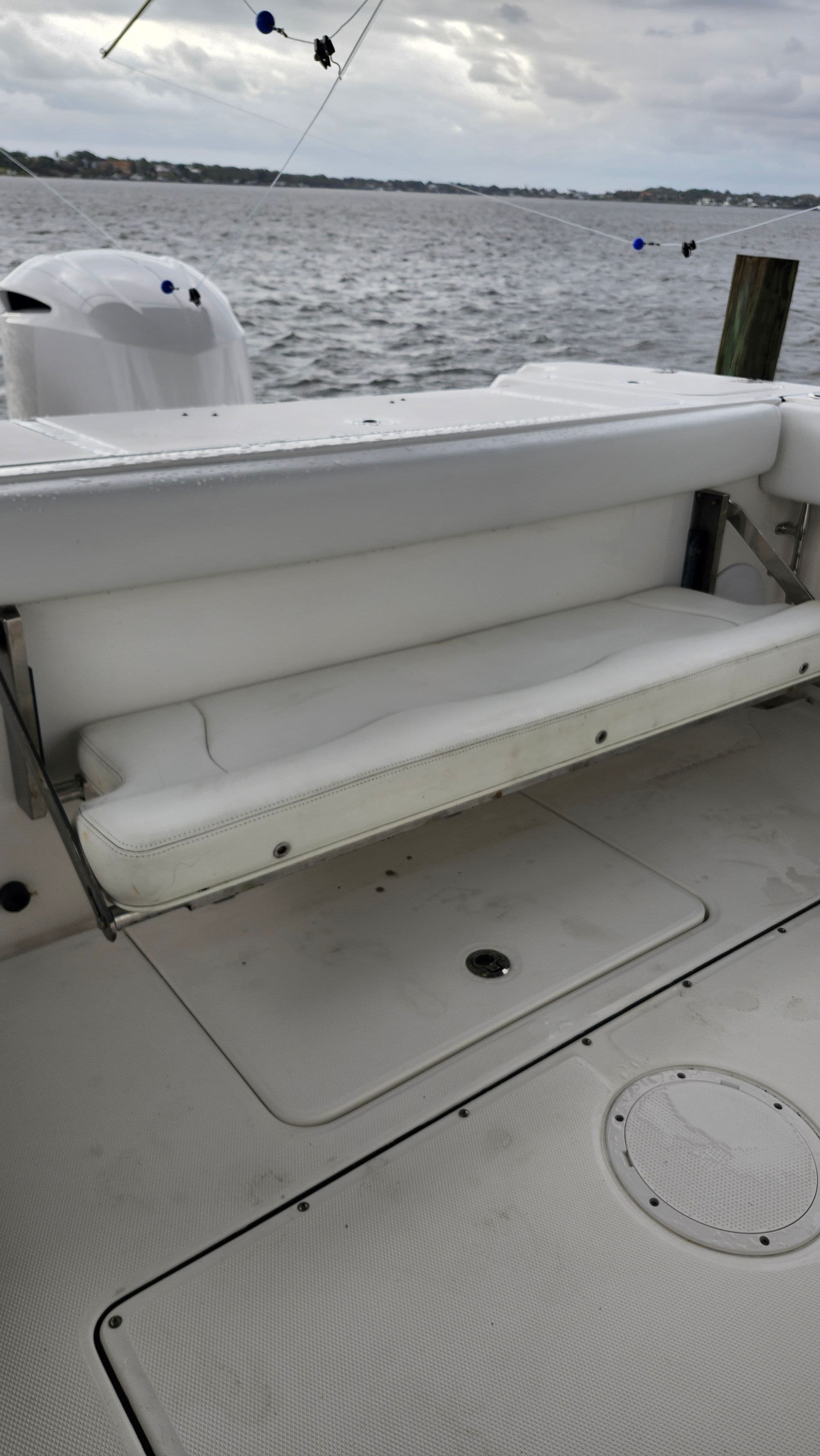 Edgewater 320CC 2018 boat with white bench seat by the water.
