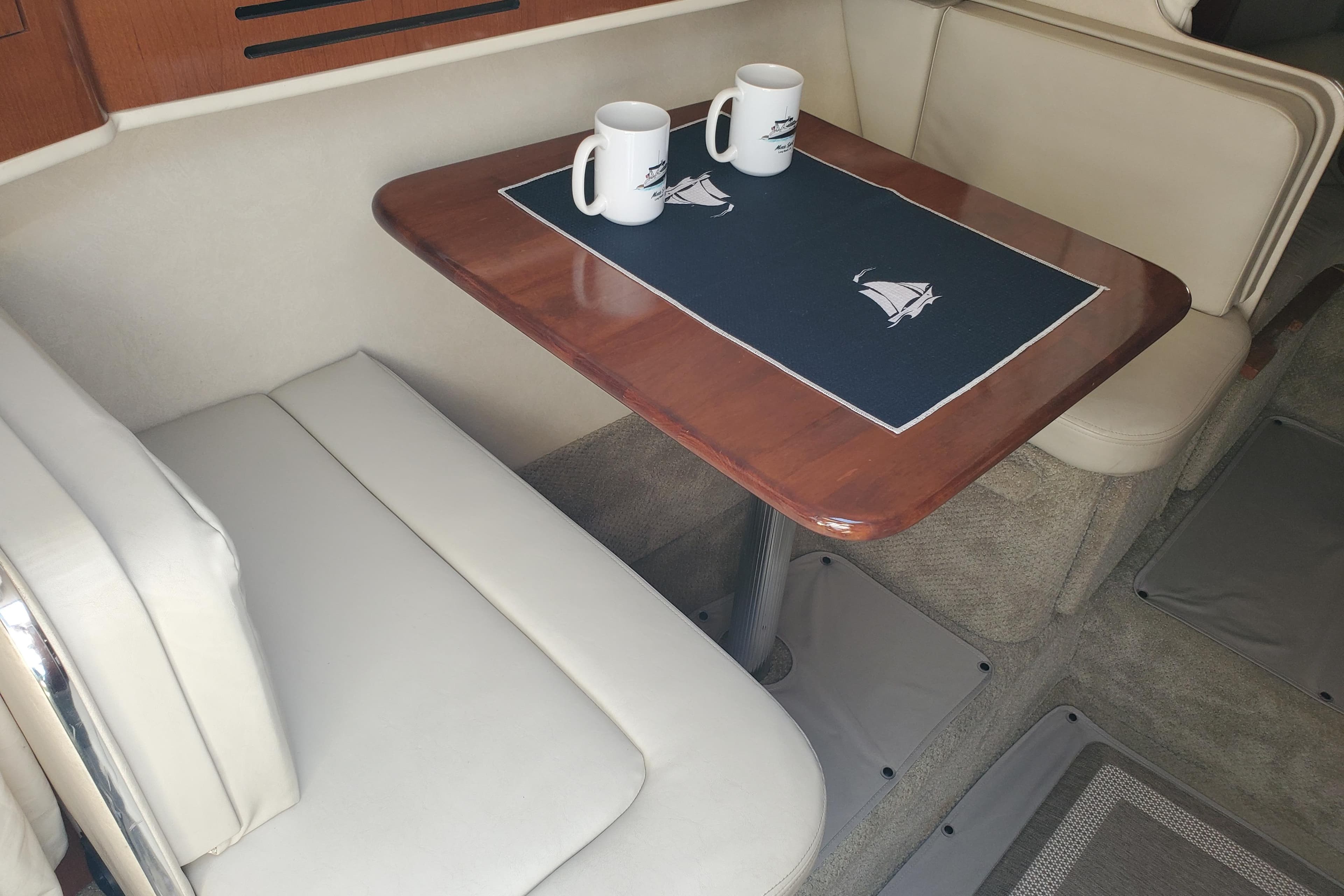 Interior of 2008 Sea Ray Sundancer 280 with table, seating, and nautical-themed decor.