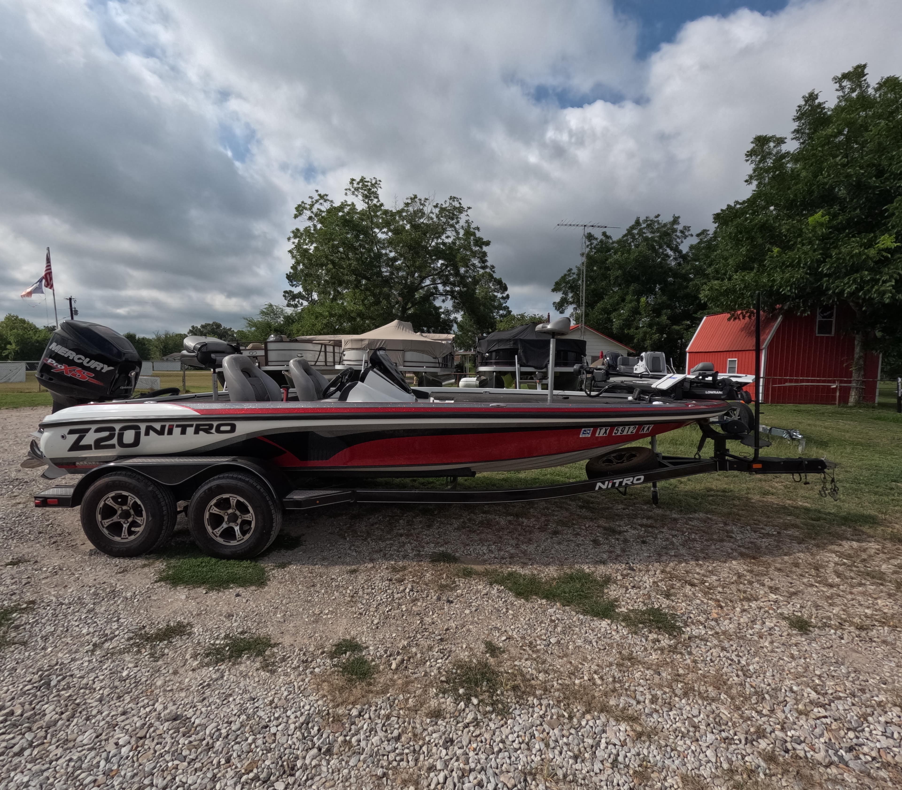 2016 Nitro Z20 boat on trailer, parked outdoors with trees and cloudy sky.