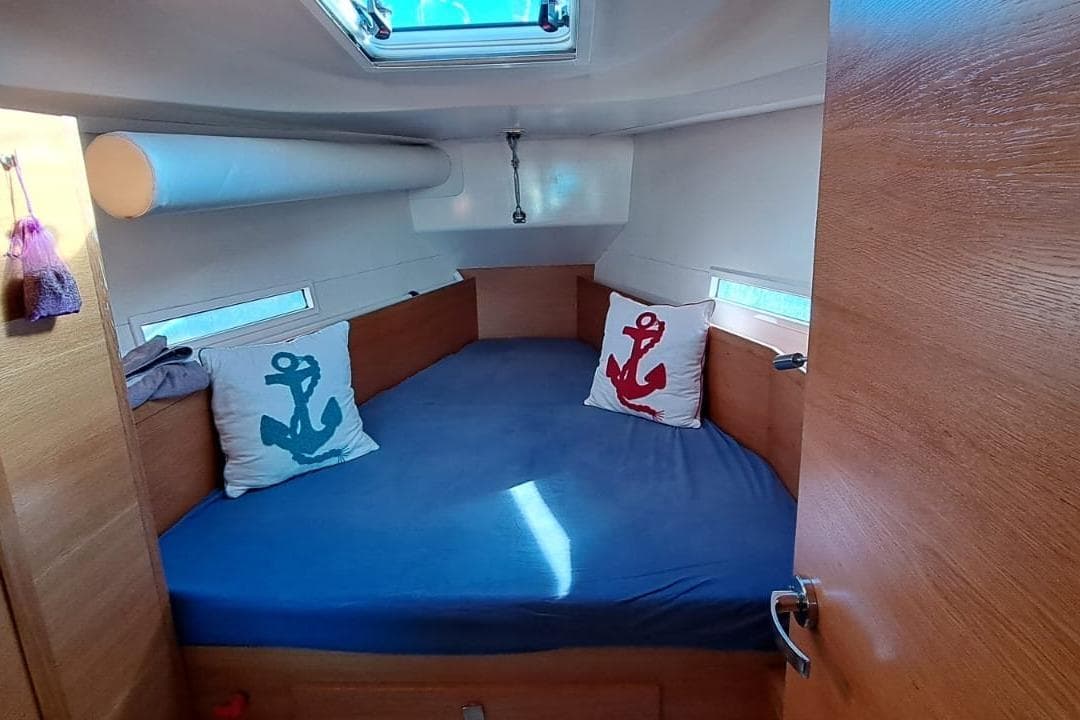 Cozy cabin interior of 2019 Salona 380 sailboat with anchor-themed pillows.