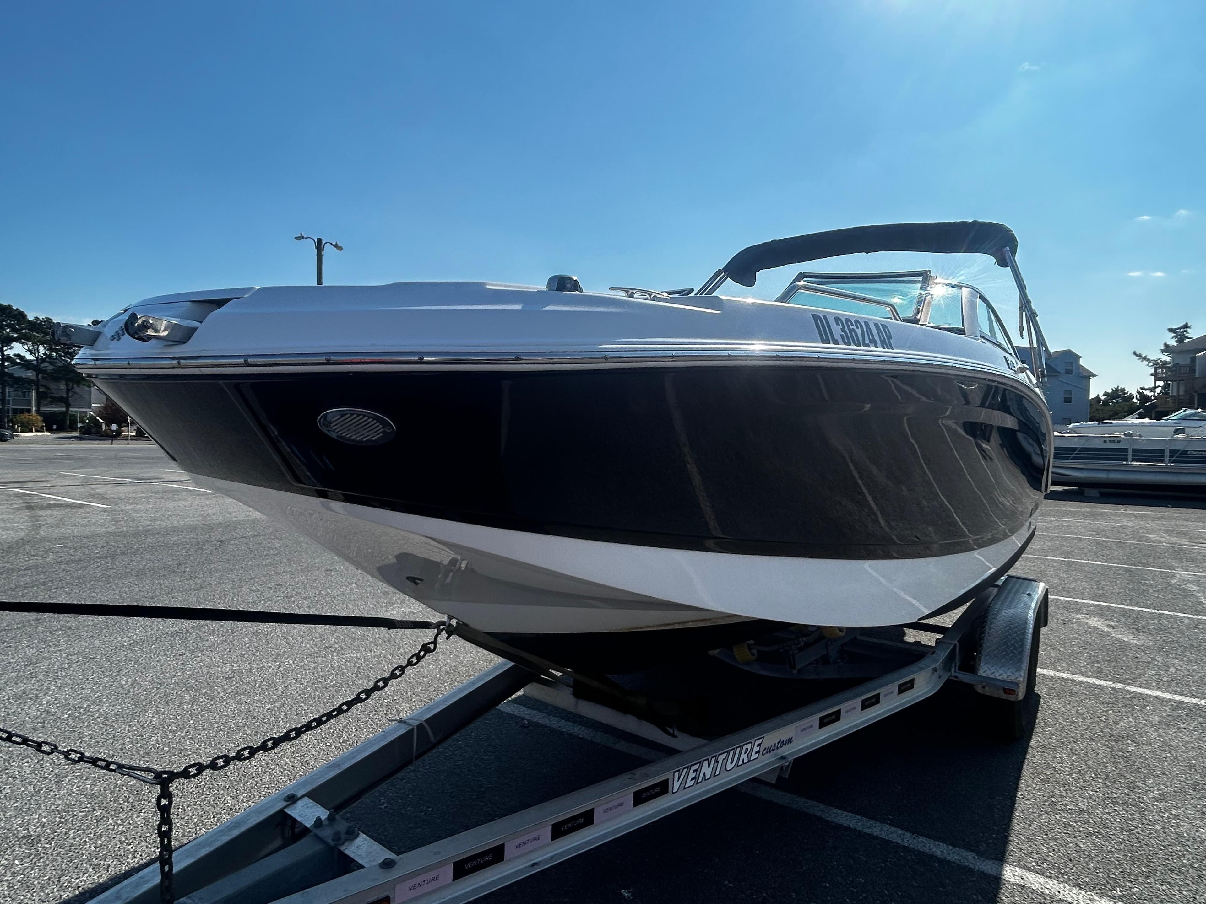 2023 Four Winns HD3 OB boat on trailer in sunny parking lot.
