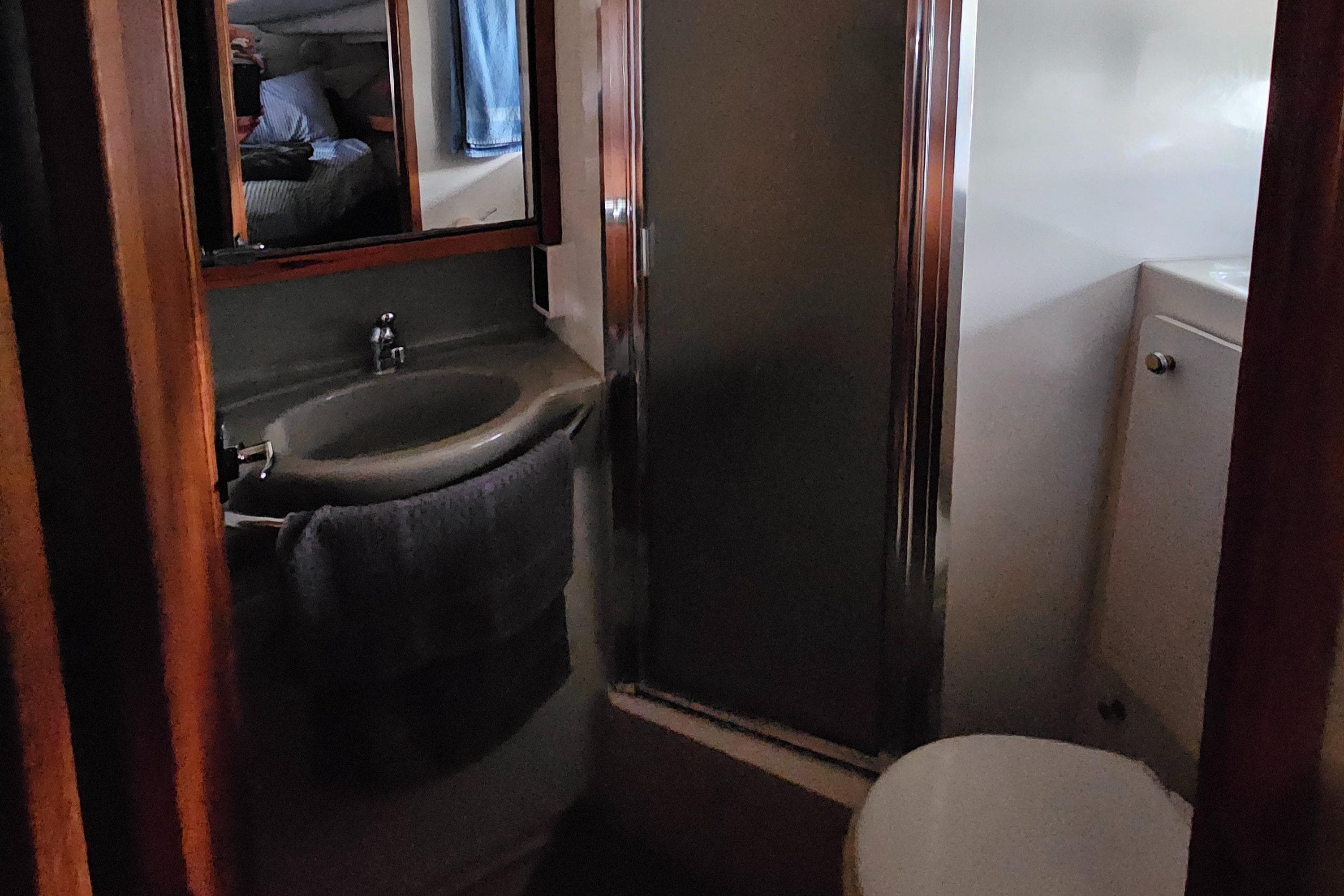 1997 Bayliner 3788 Command Bridge Motoryacht bathroom with sink, mirror, and shower.