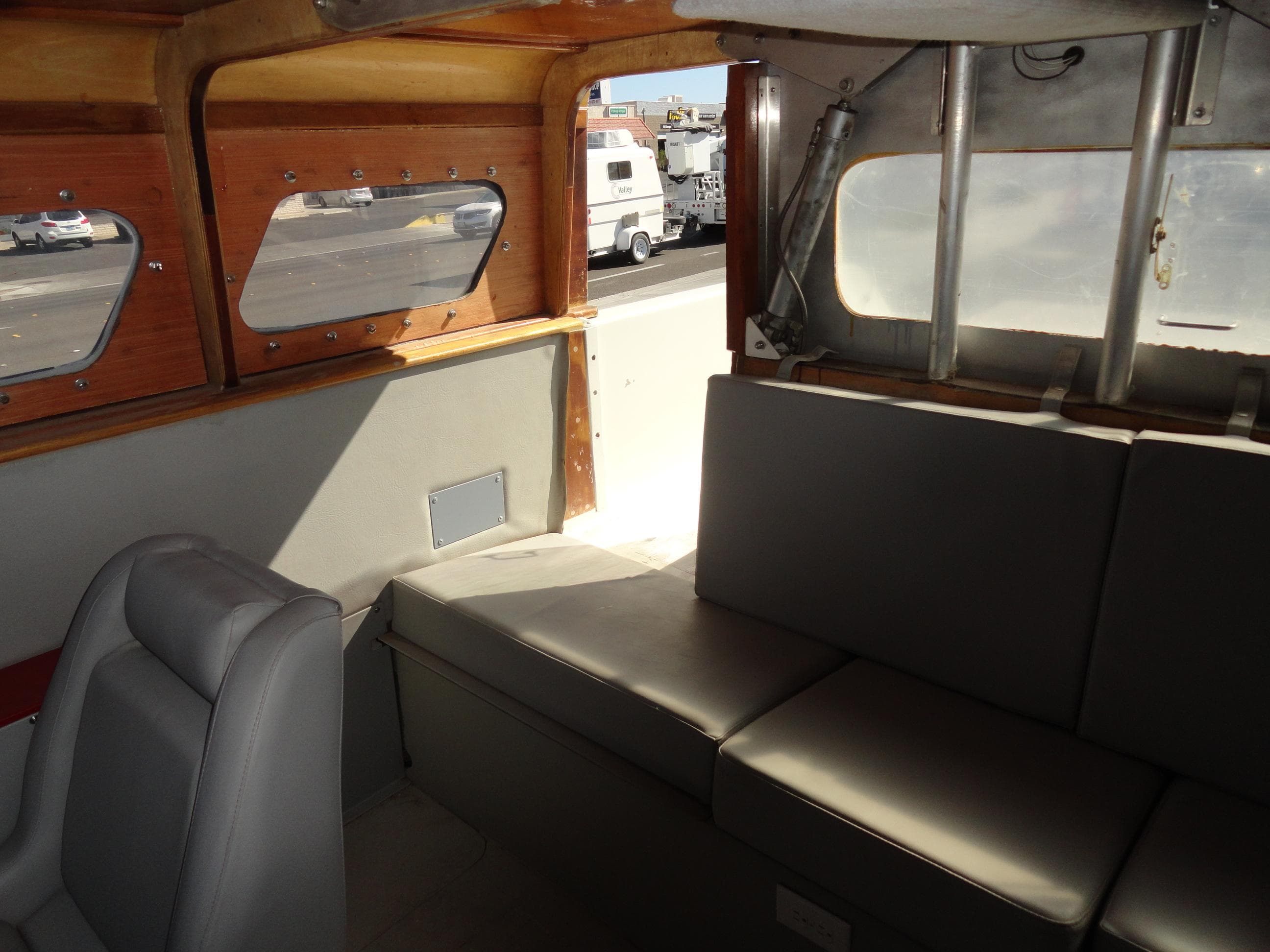 Interior of 1996 Hallett Party Cruiser Gull Wing 300 with grey seating and wooden accents.