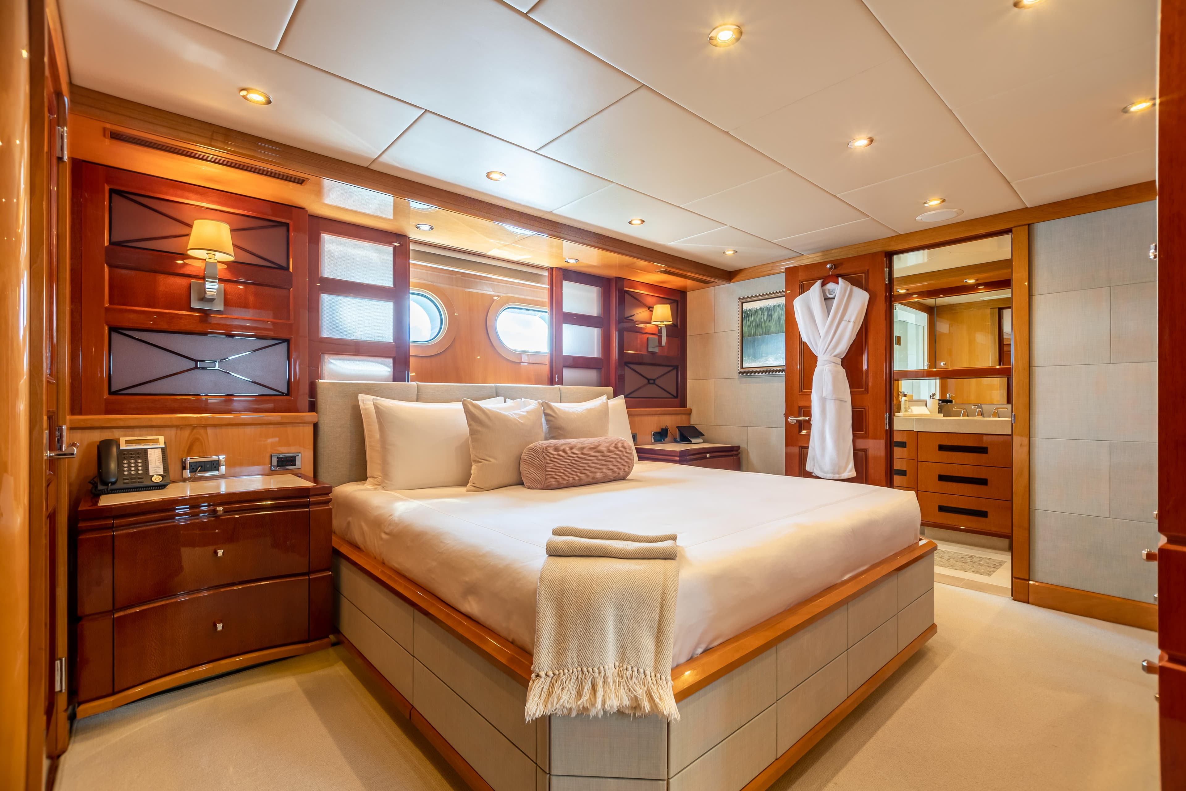 Luxurious bedroom on a 2011 Trinity Yachts CUSTOM yacht with elegant wood finishes.