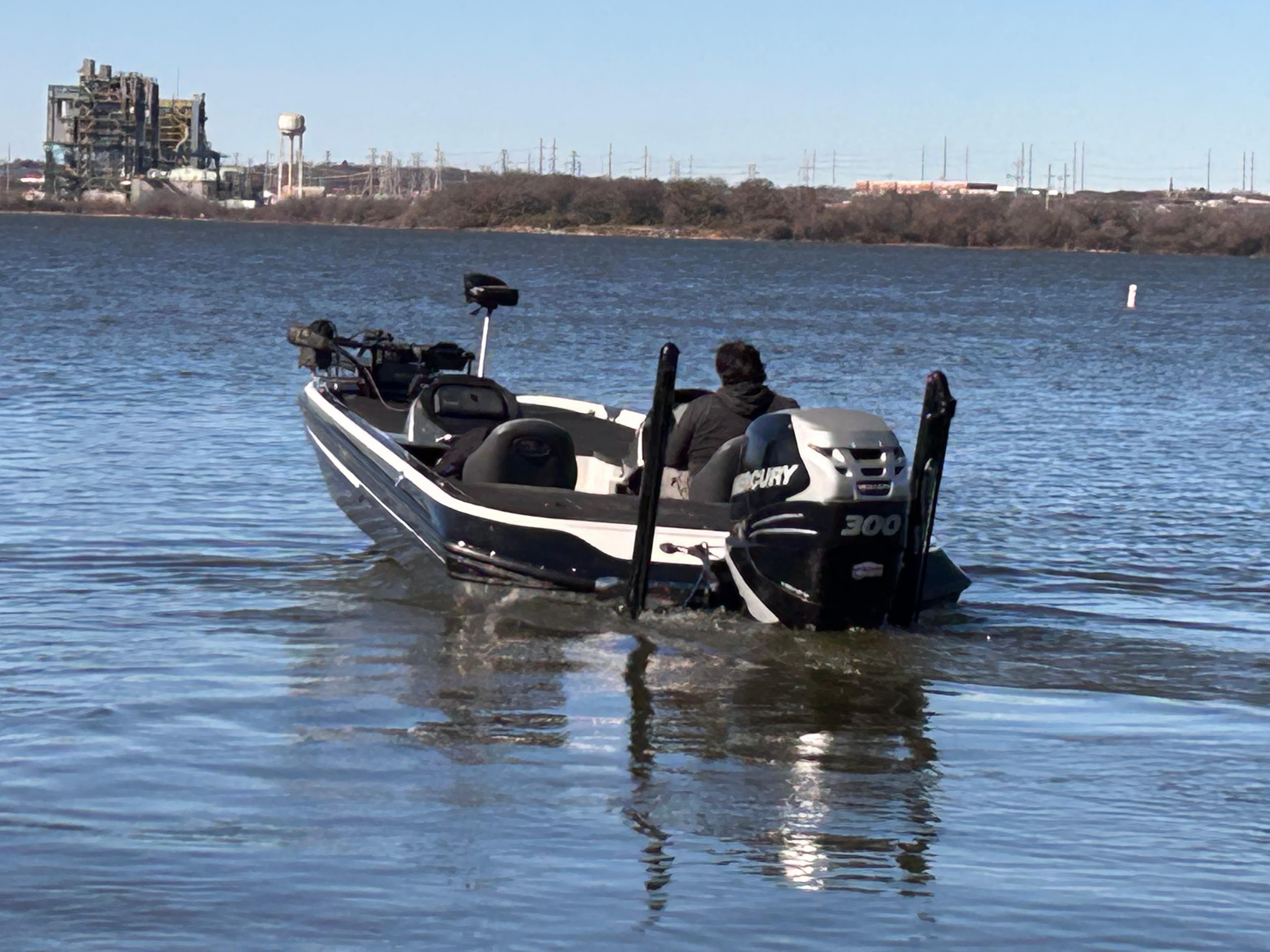 2009 Champion 210 Elite boat on a lake with Mercury 300 engine.