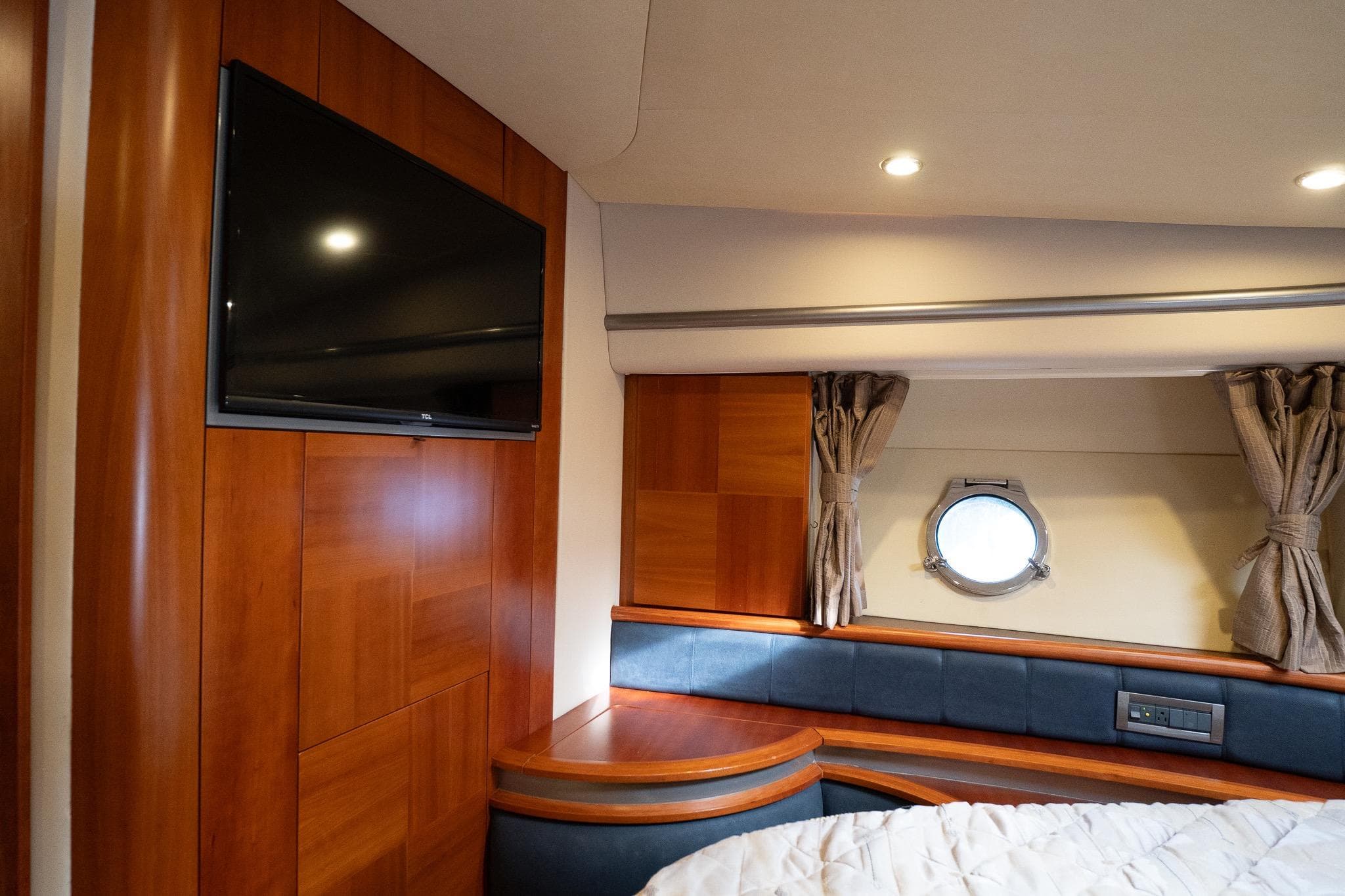 Luxurious interior of 2008 Azimut Fly 50 yacht with wood paneling and porthole window.