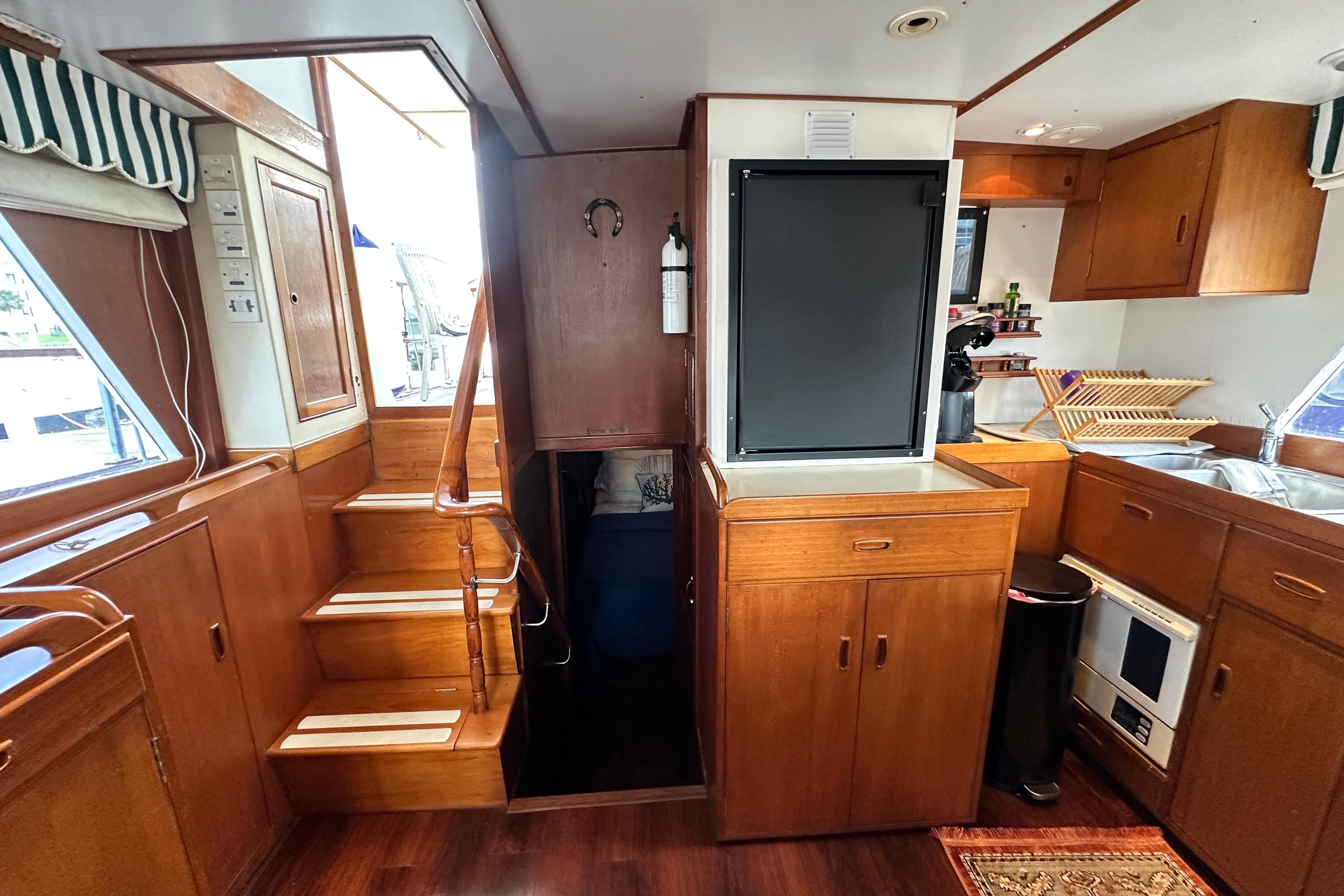 Interior of 1980 Island Gypsy Flush Aft Deck Trawler-Motor Yacht with wooden cabinetry and stairs.