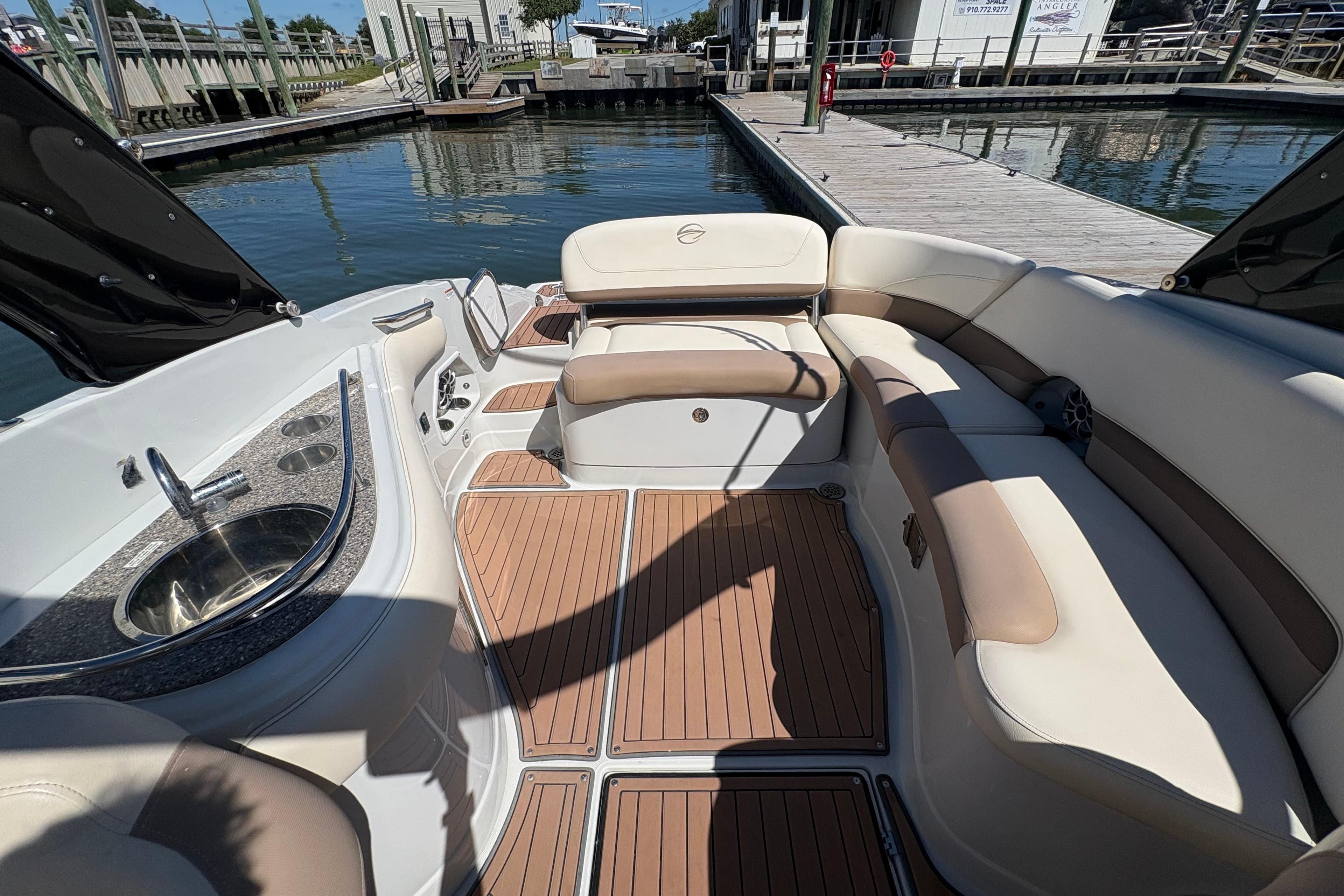 2017 Crownline 275 SS boat interior with seating and sink, docked by the water.