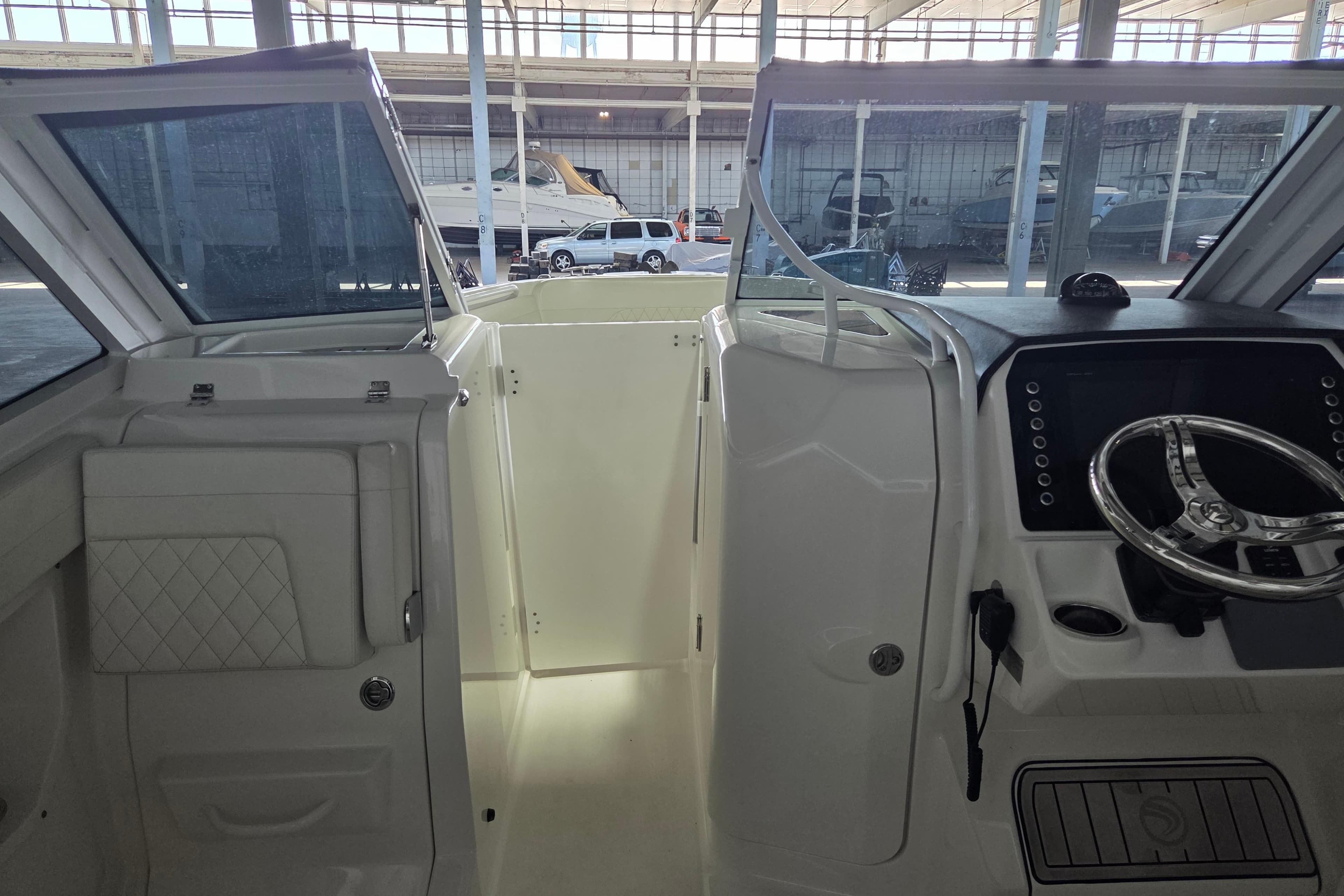 Interior view of 2019 Edgewater 262CX Crossover boat cockpit with steering wheel.