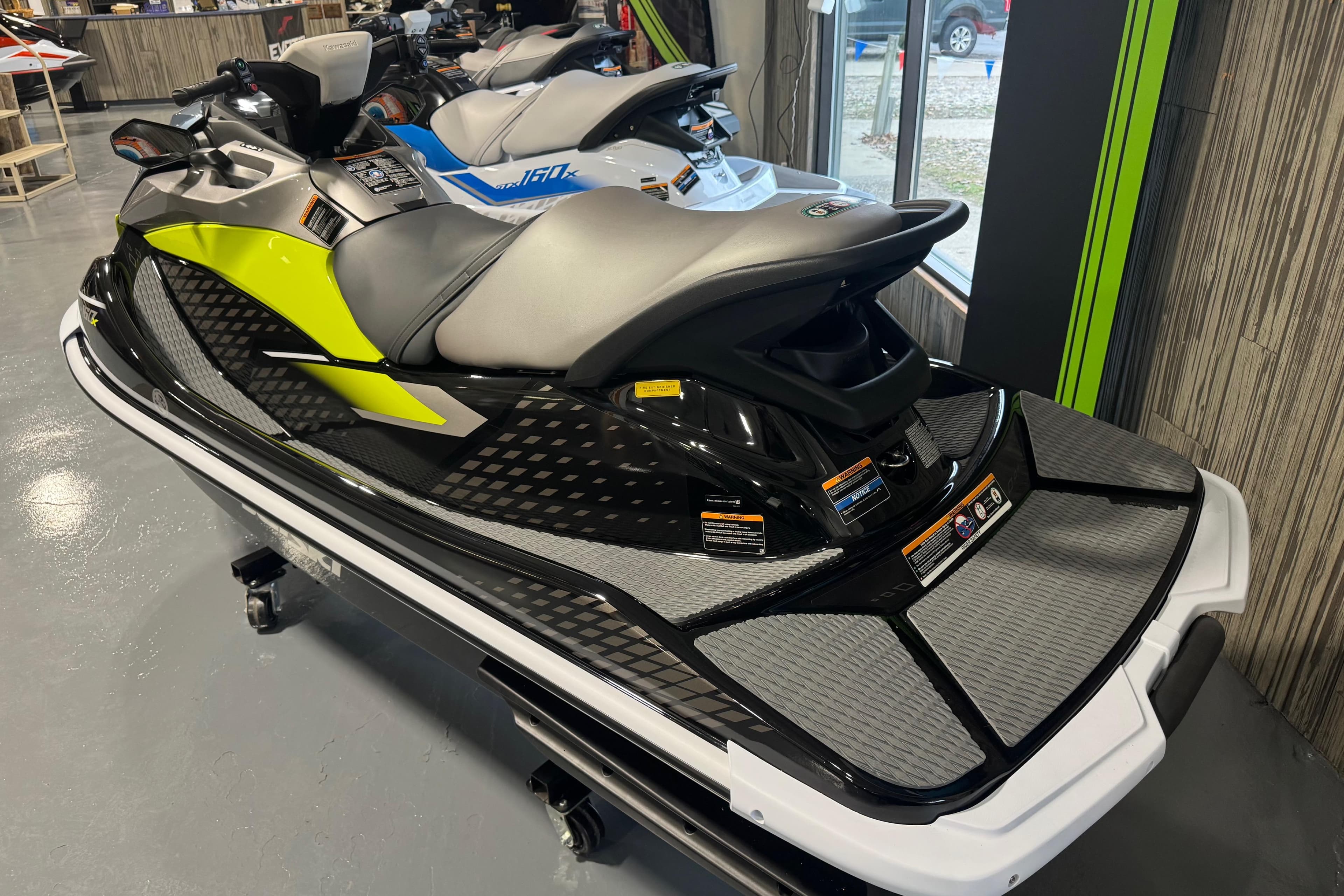 2026 Kawasaki ST160X jet ski in showroom, featuring sleek design and vibrant colors.