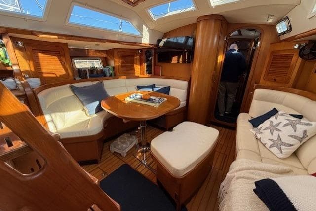 Luxurious interior of 2002 Hylas 46 yacht with cozy seating and wooden finishes.