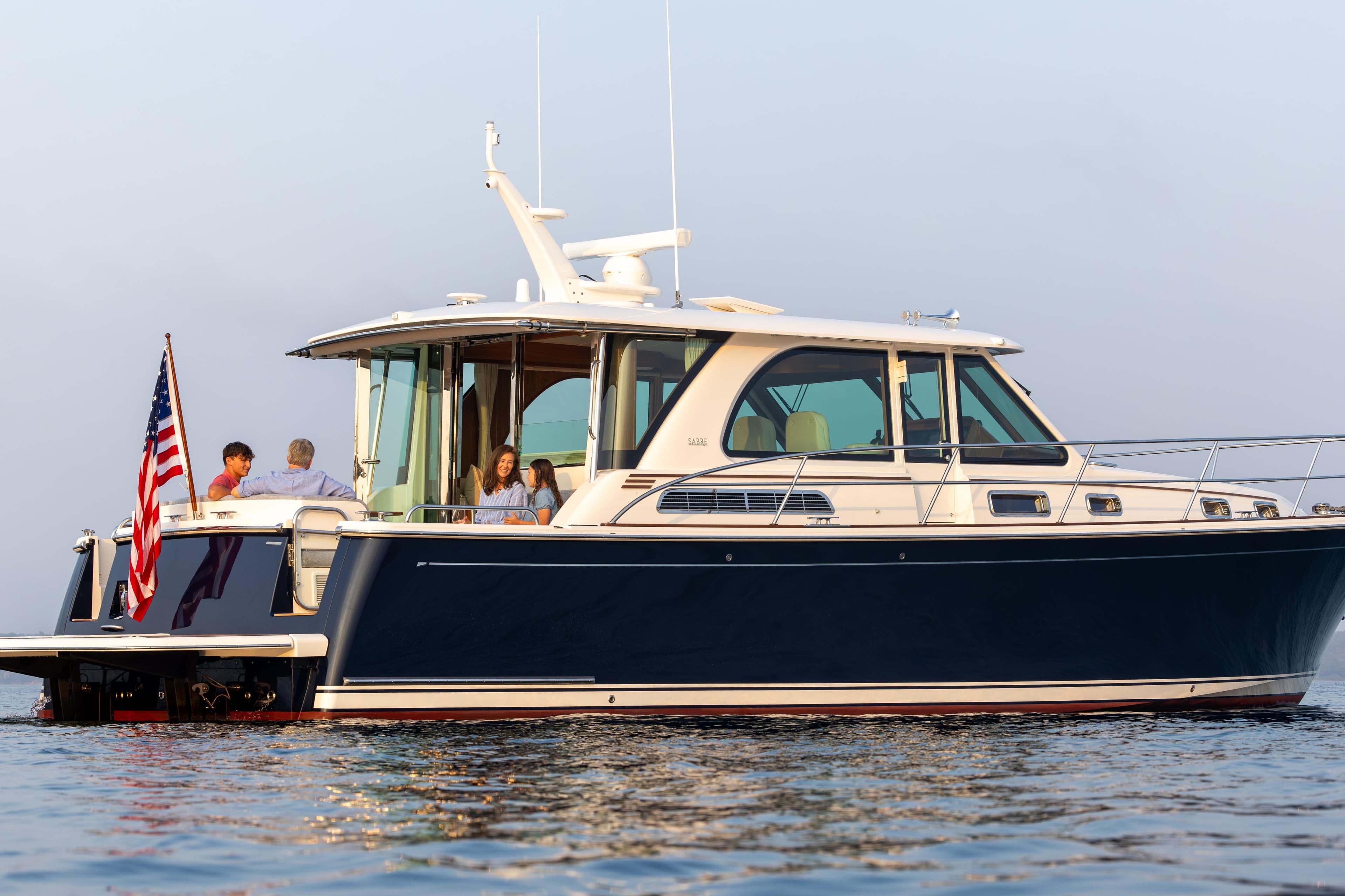 2027 Sabre 45 Salon Express yacht on water with people enjoying the view.
