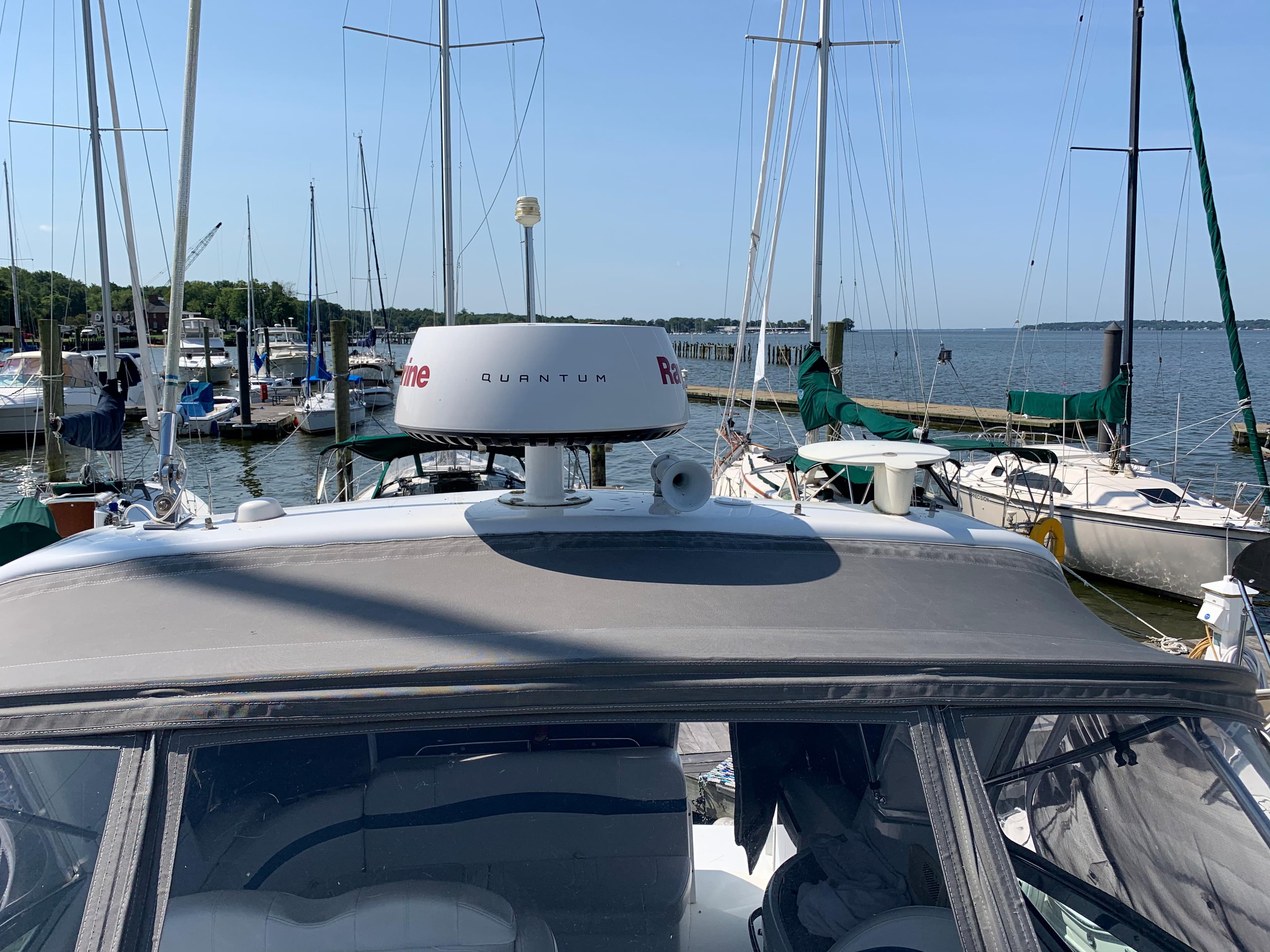 2005 Formula 34 Performance Cruiser docked at marina with sailboats in background.