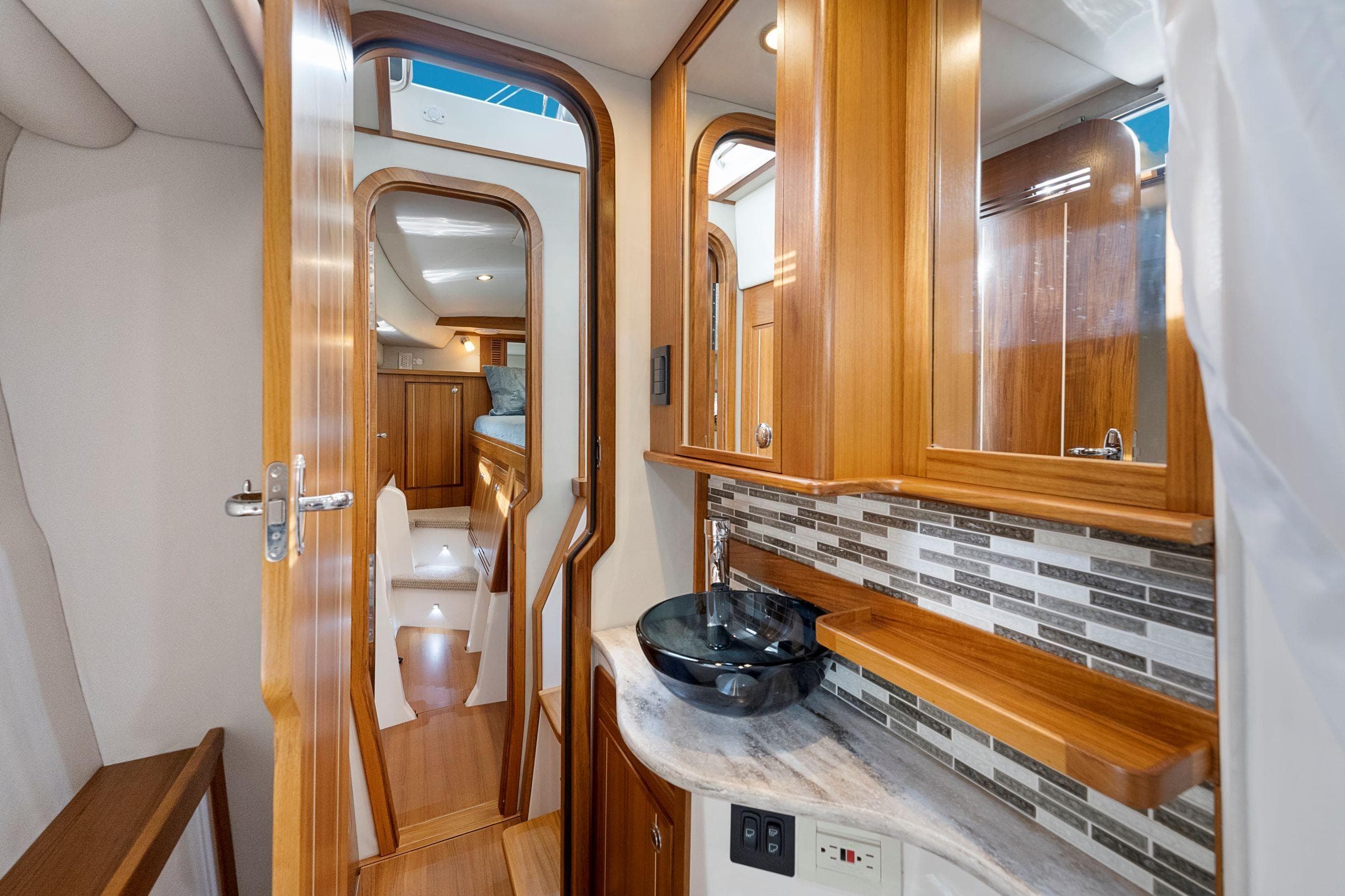 Luxurious interior of 2026 Aspen C128 Flybridge yacht with wood finish and modern amenities.