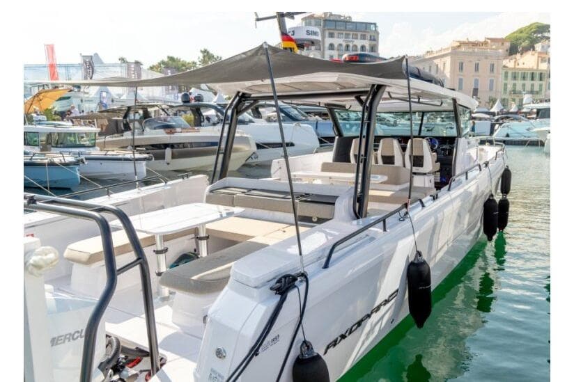 2027 Axopar 45 Cross Top boat docked at marina, showcasing sleek design and spacious seating.
