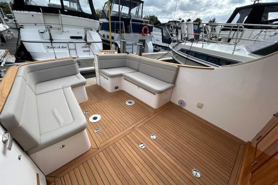 Cockwells Duchy 35, 2019 model, featuring elegant teak deck and comfortable seating in a marina setting.
