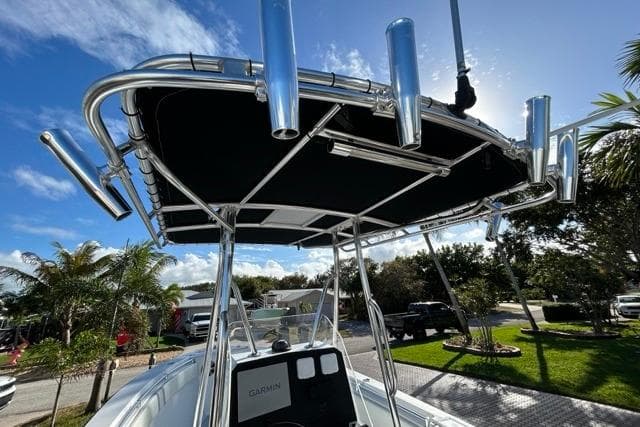 2006 Contender 21 Open boat with T-top and rod holders under a sunny sky.