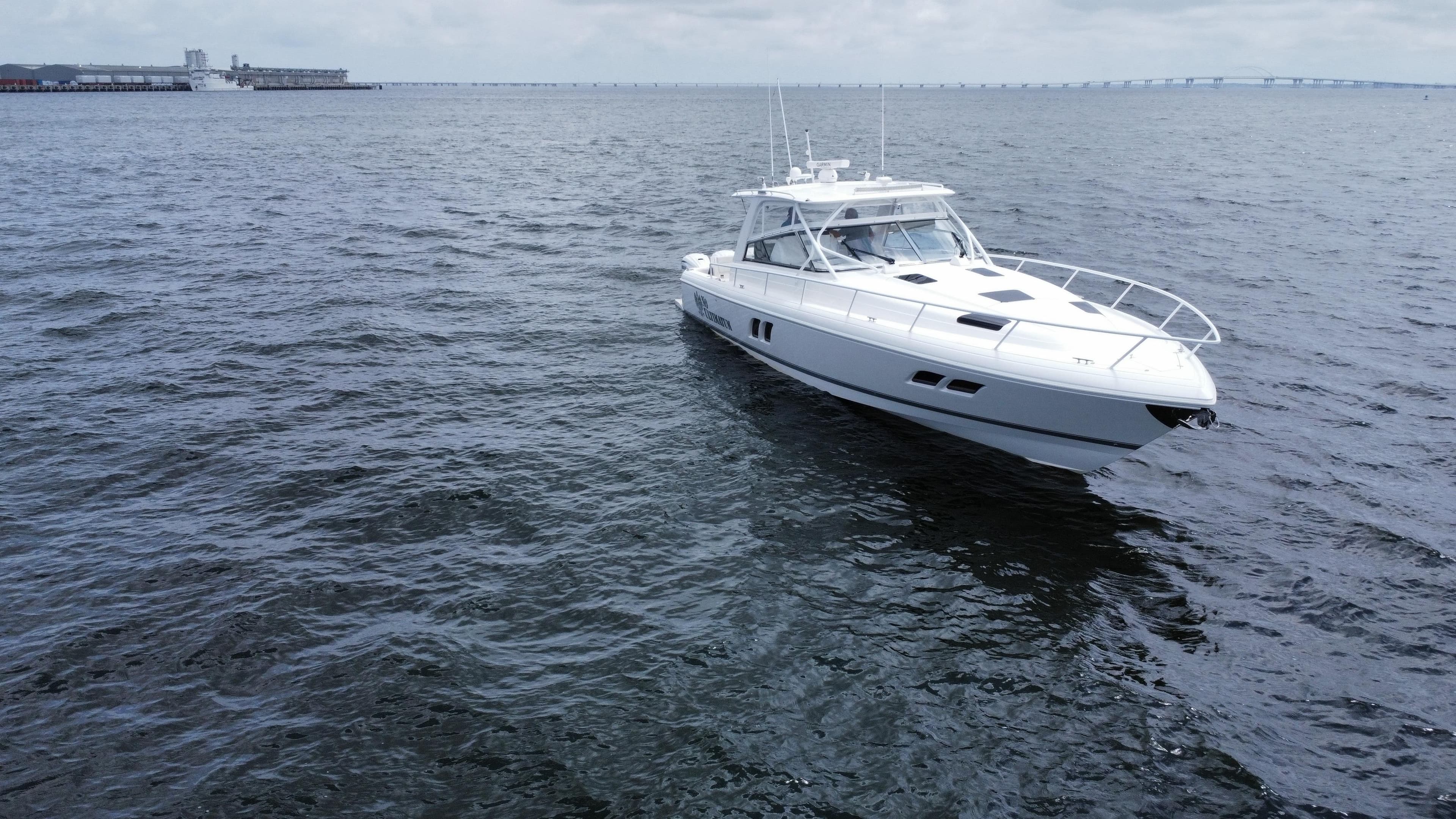 2020 Intrepid 475 Sport Yacht cruising on open water under cloudy skies.
